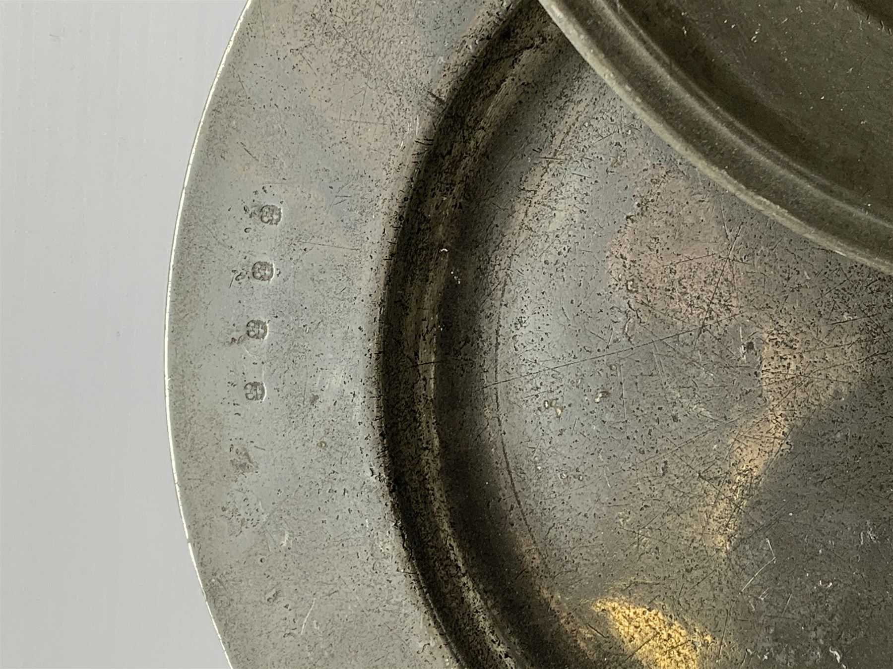 Collection of 18th and 19th century pewter, comprising two chargers, eight large plates, twenty six smaller plates, two bowls, three lidded measures, two jugs, tappit hen, and tankard, the plates with various marks and touch marks, including pseudo 'hallmarks', largest charger 37cm, large plates D30cm, smaller plates D24.5cm, tappit hen H26.5cm