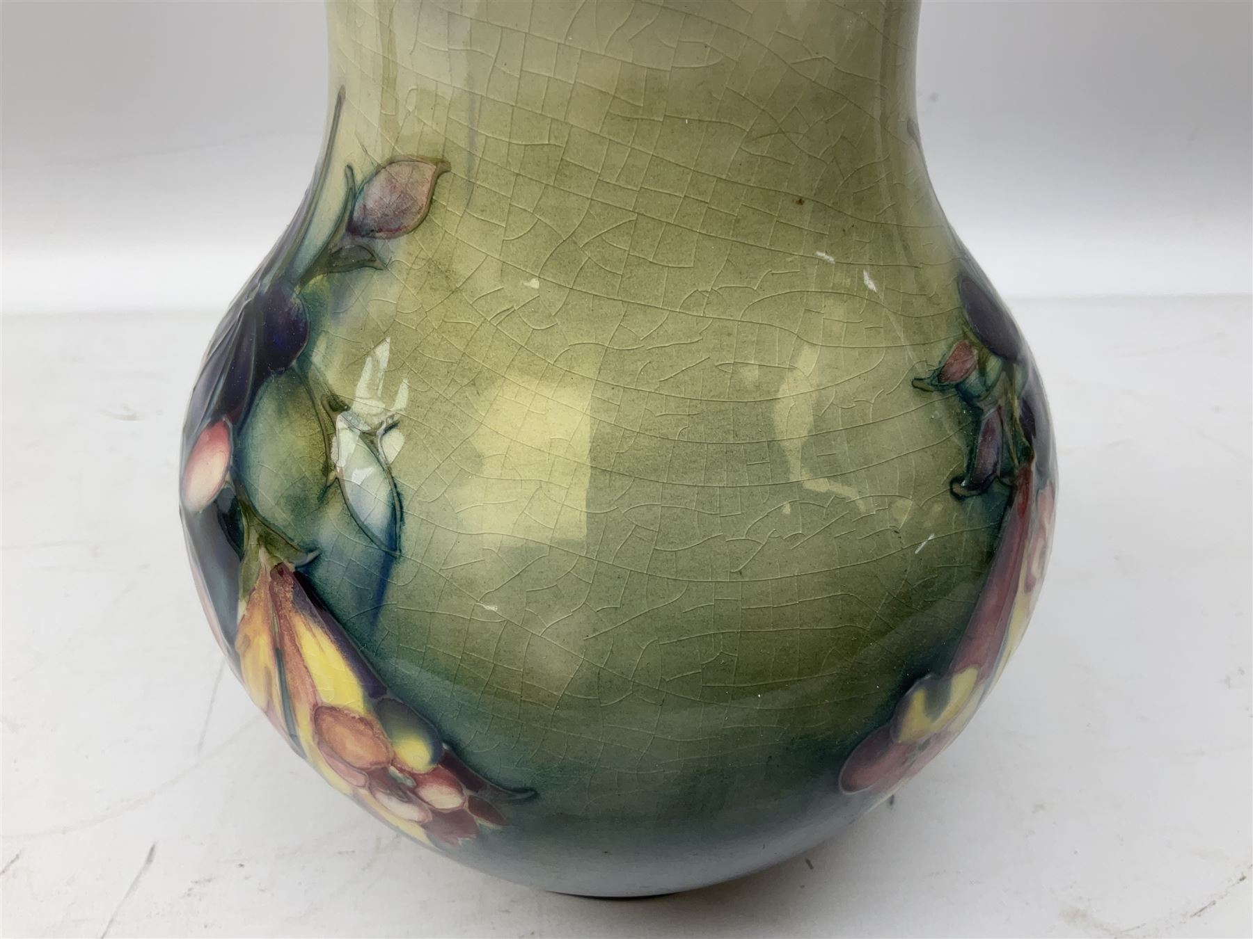 Moorcroft vase of baluster form decorated in the Spring Flowers pattern upon a merging green and blue ground, with impressed and painted marks beneath, H22.5cm