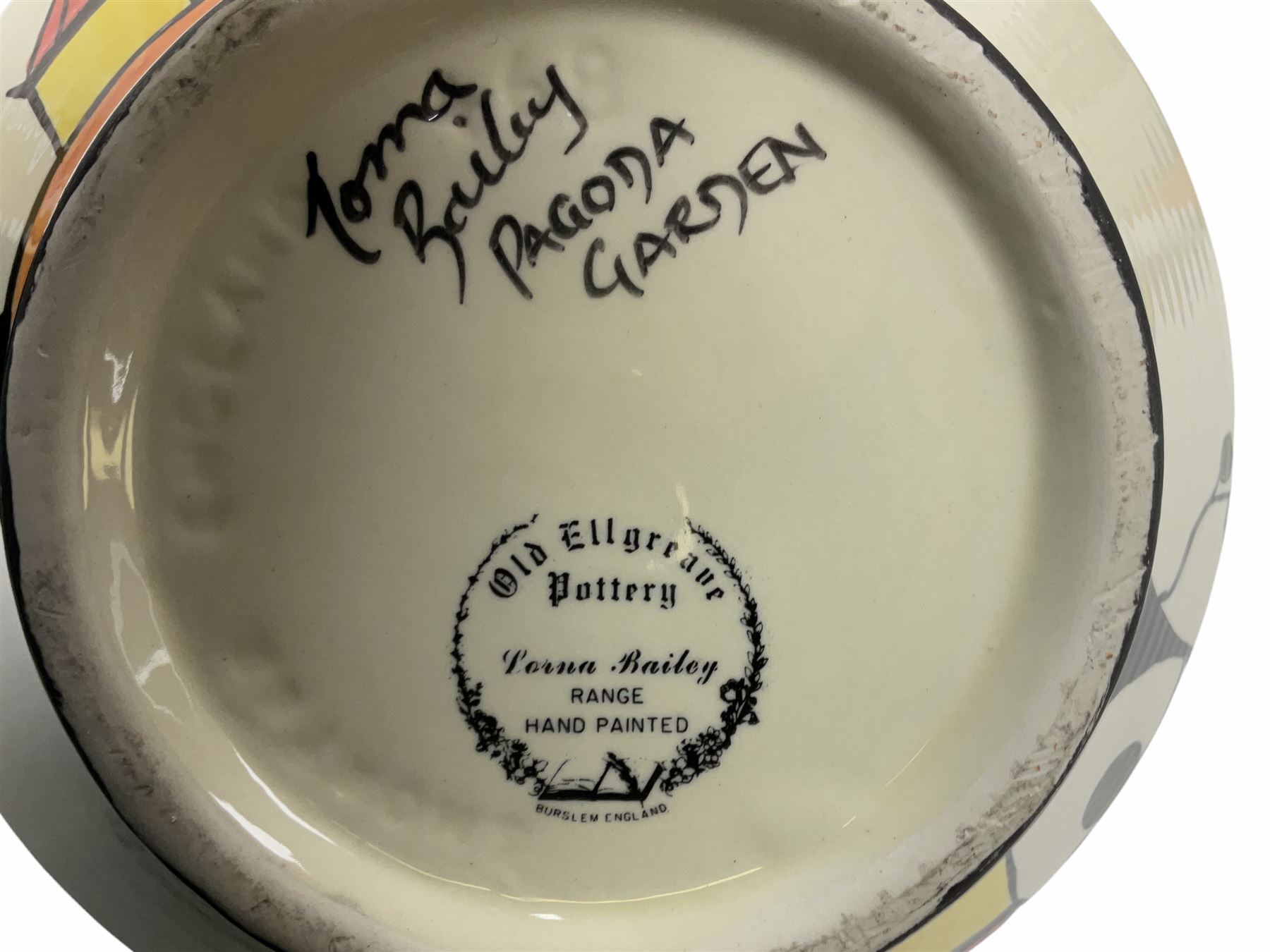 Lorna Bailey Old Ellgreave Pottery, comprising teapot in beach design, circular jar in house and path design, shell jug in Bridge and stream design, squat jug in Pagoda design and plate decorated with an Art Deco woman, all with printed and painted marks. 