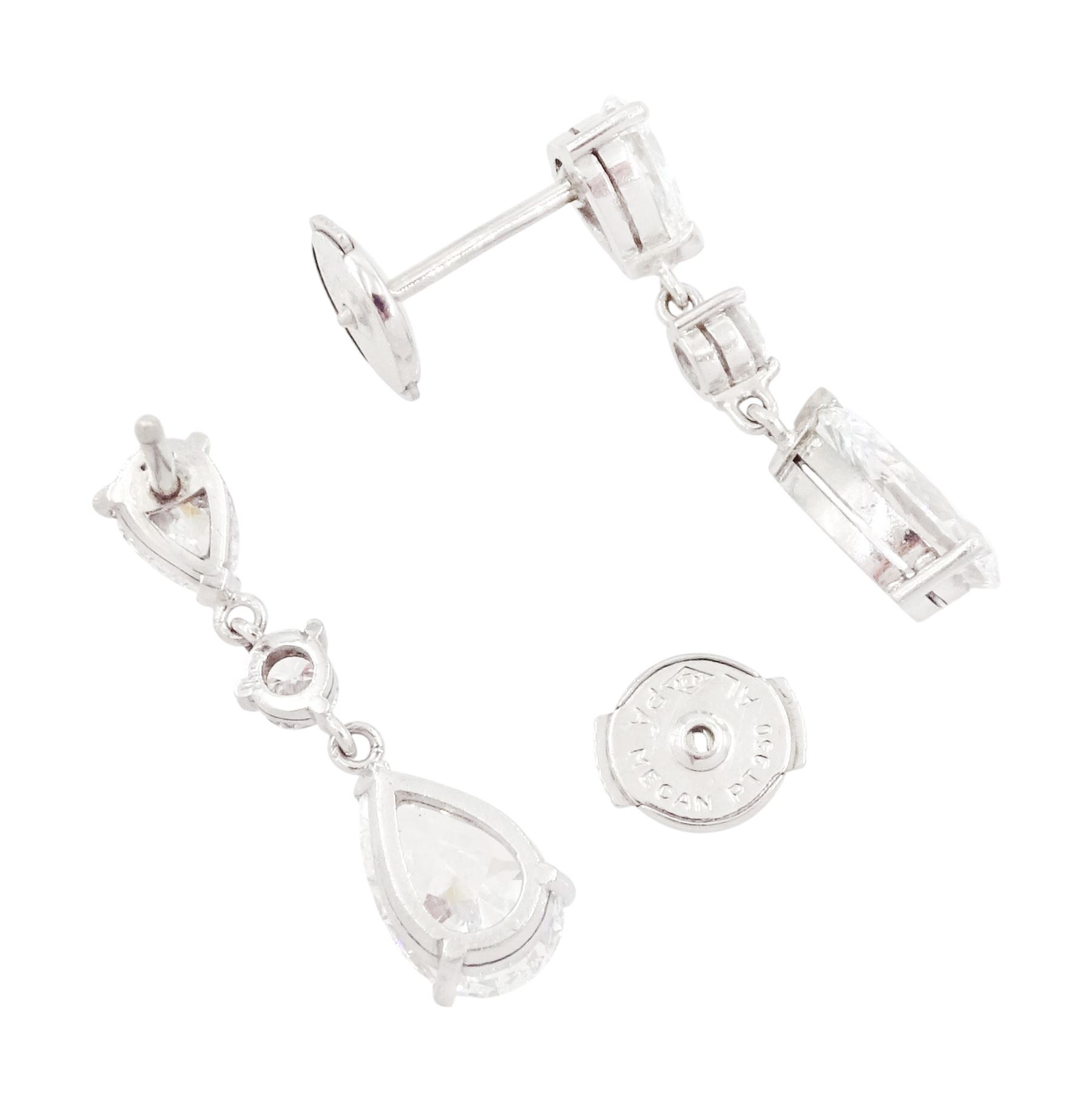 Pair of platinum diamond pendant earrings, each stud set with two pear cut diamonds, of 1.01 carat, 1.02 carat, 0.30 carat and 0.32 carat, spaced by a round brilliant cut diamond, total diamond weight 2.65 carat, each pear cut with a GIA certificate