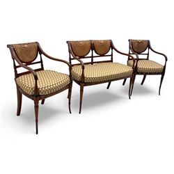 Edwardian Sheraton Revival inlaid mahogany parlour suite, comprising a two-seater settee and two matching armchairs, each with fan-shaped caned back, shaped crest rail with foliate inlay, scrolled open arms, upholstered seat with repeating geometric pattern, on turned and tapered front supports