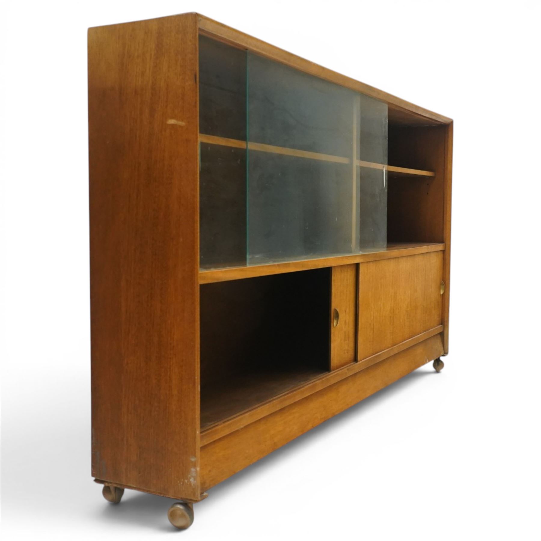 Herbert E Gibbs - Mid 20th century teak bookcase with sliding glazed doors, glazed upper section with adjustable shelf, above to two teak doors, raised on castors