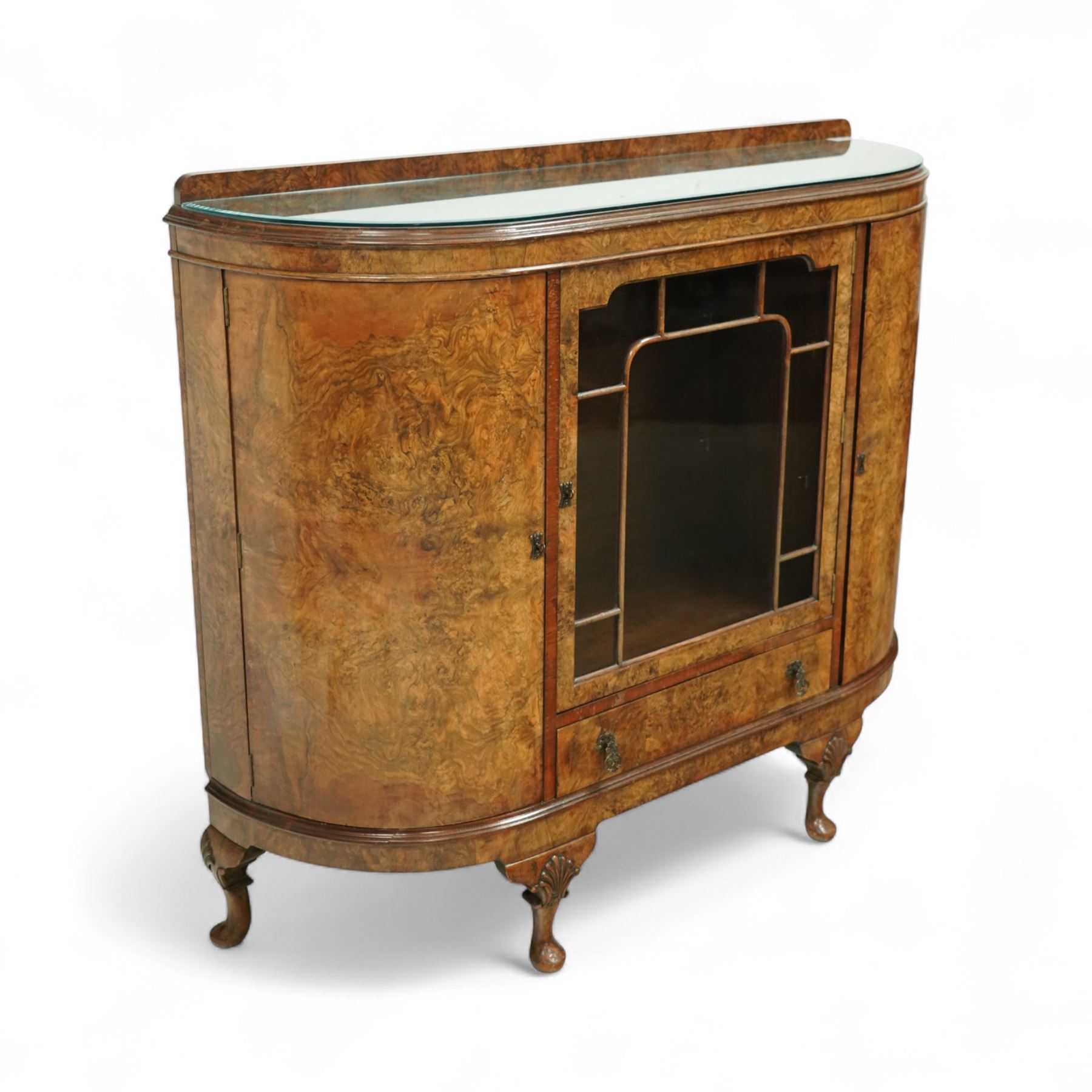 Early 20th century burr walnut display side cabinet, the glass inset top over a central glazed door with geometric astragal glazing, flanked by curved cupboards, shaped apron fitted with drawer, on cabriole legs with shell carved knees and pad feet