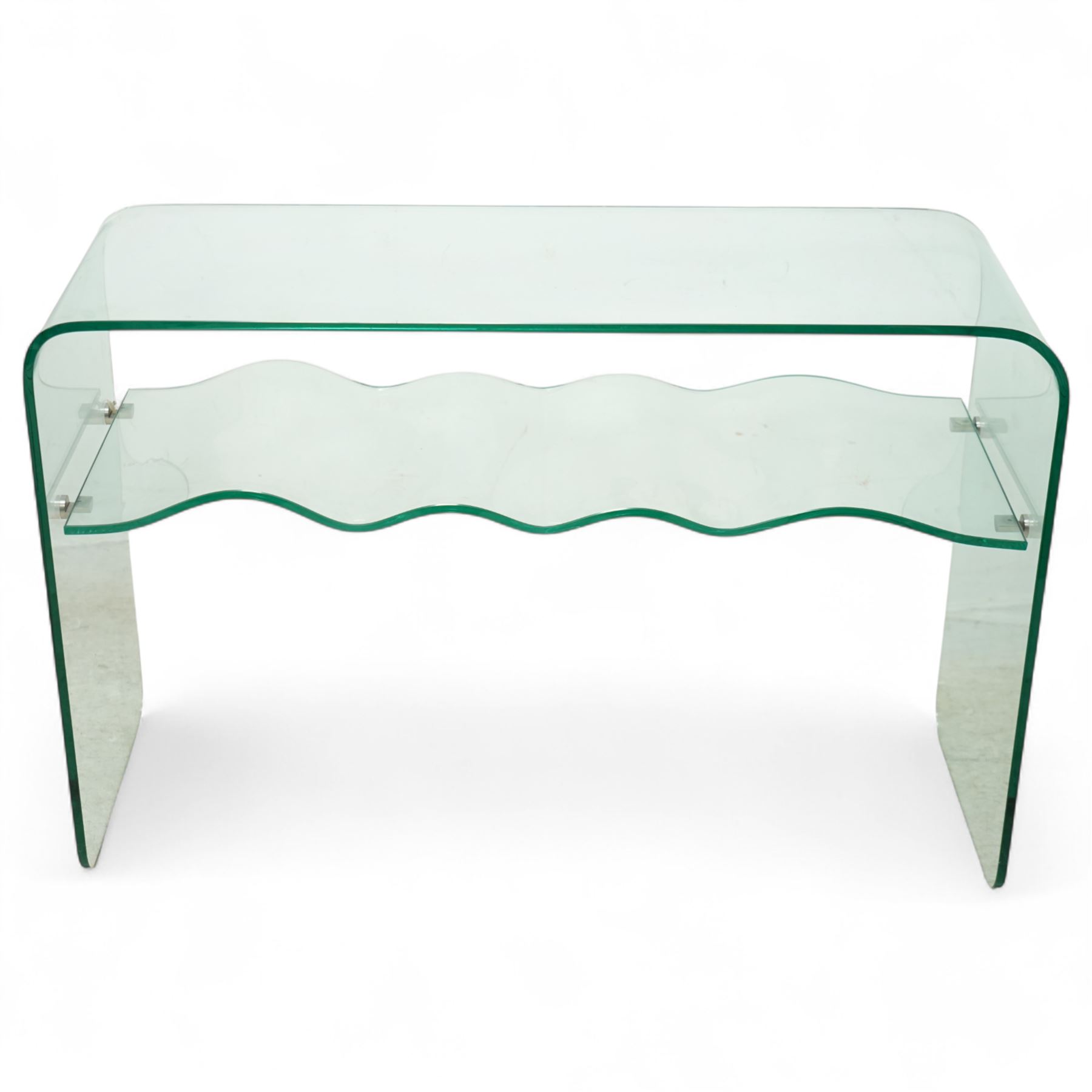 Contemporary glass two-tier console table of minimalist design, rectangular top with a single sheet of curved glass with a waved under tier supported with metal fittings 