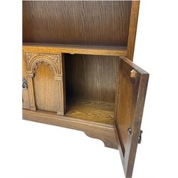 Medium oak bookcase, two shelves over two cupboards and central arch decoration