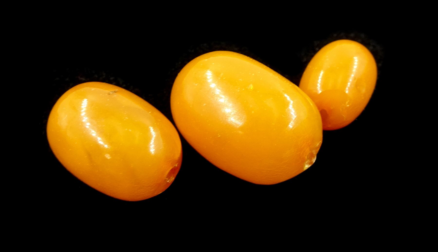 Single strand graduating oval butterscotch amber bead necklace, with three additional loose amber beads