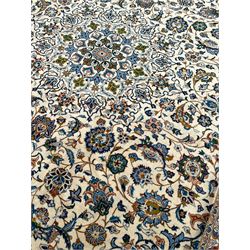 Persian Kashan ivory ground carpet, the interlaced foliate medallion surrounded by trailing plant motifs interlaced with scrolls, the guarded border with repeating stylised flower heads