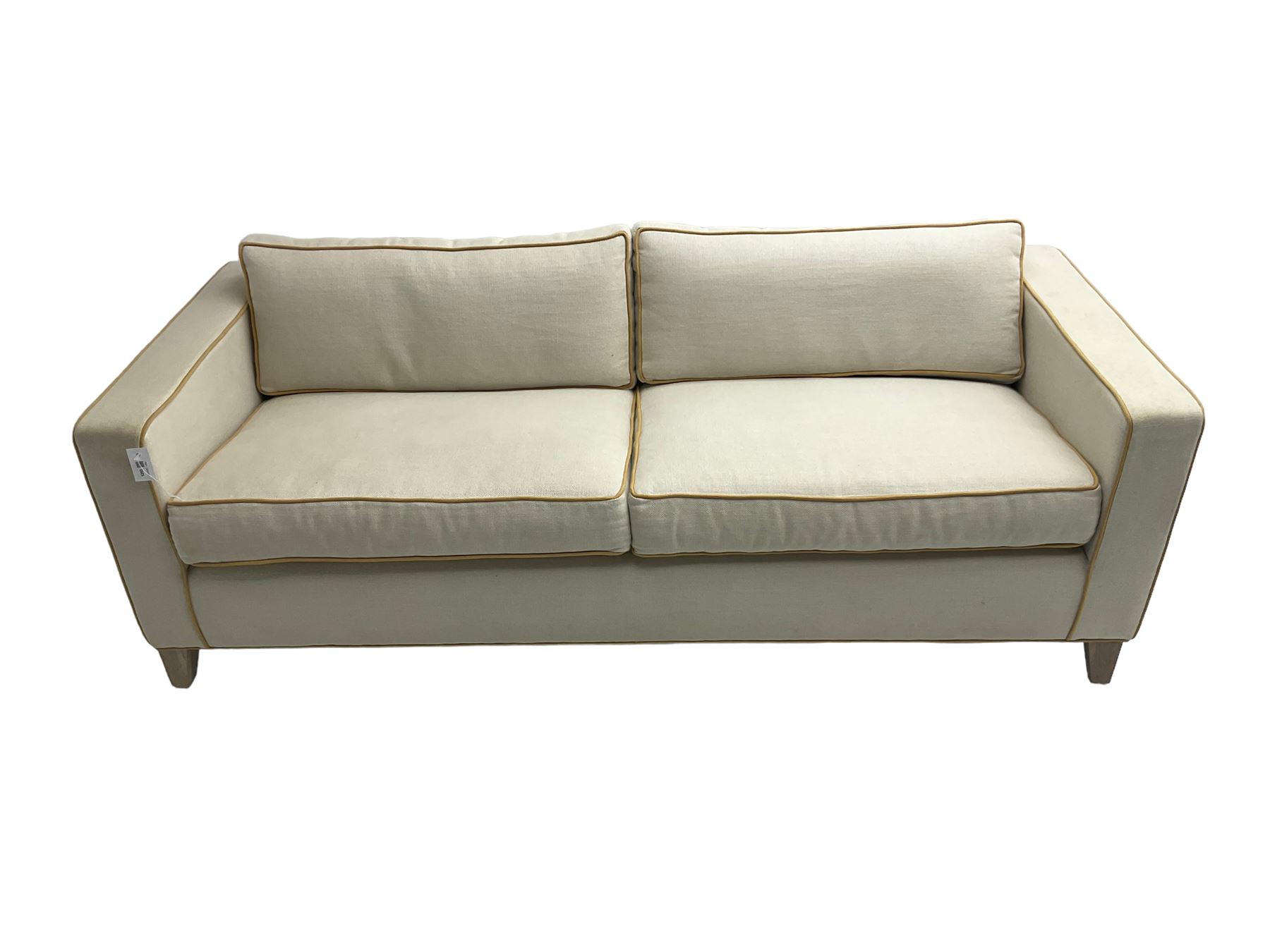 Neptune - pair three seat 'Shoreditch' sofas,  upholstered in cream fabric with yellow stringing