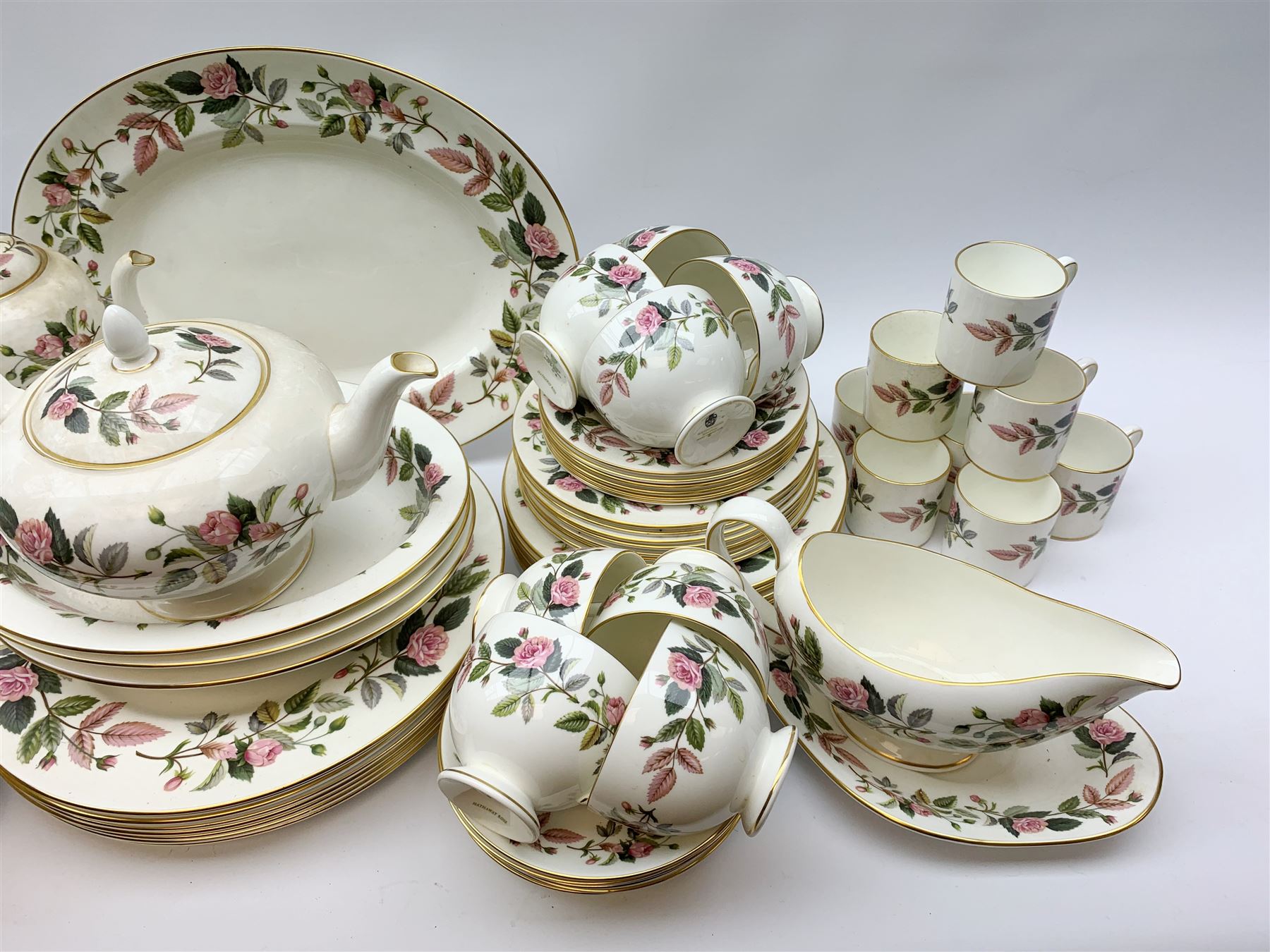 Wedgwood Hathaway Rose pattern dinner and tea wares, comprising eight dinner plates, eight salad plates, eight dessert plates, six side plates, six soup bowls and six saucers, sauce boat and stand, three oval serving dishes, oval serving platter, teapot, coffee pot, eight tea cups and eight saucers, eight coffee cans and eight saucers, two open sucriers, milk jug, cream jug, two ashtrays, and a lidded box and cover. 