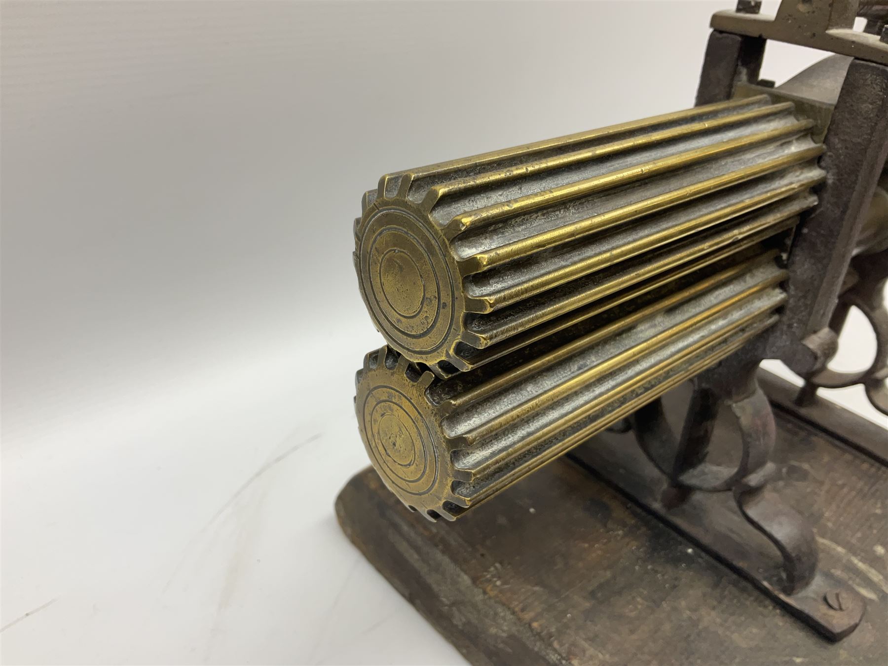 Victorian cuff and collar tabletop mangle, the ribbed brass rollers in a cast iron frame mounted on a wooden base