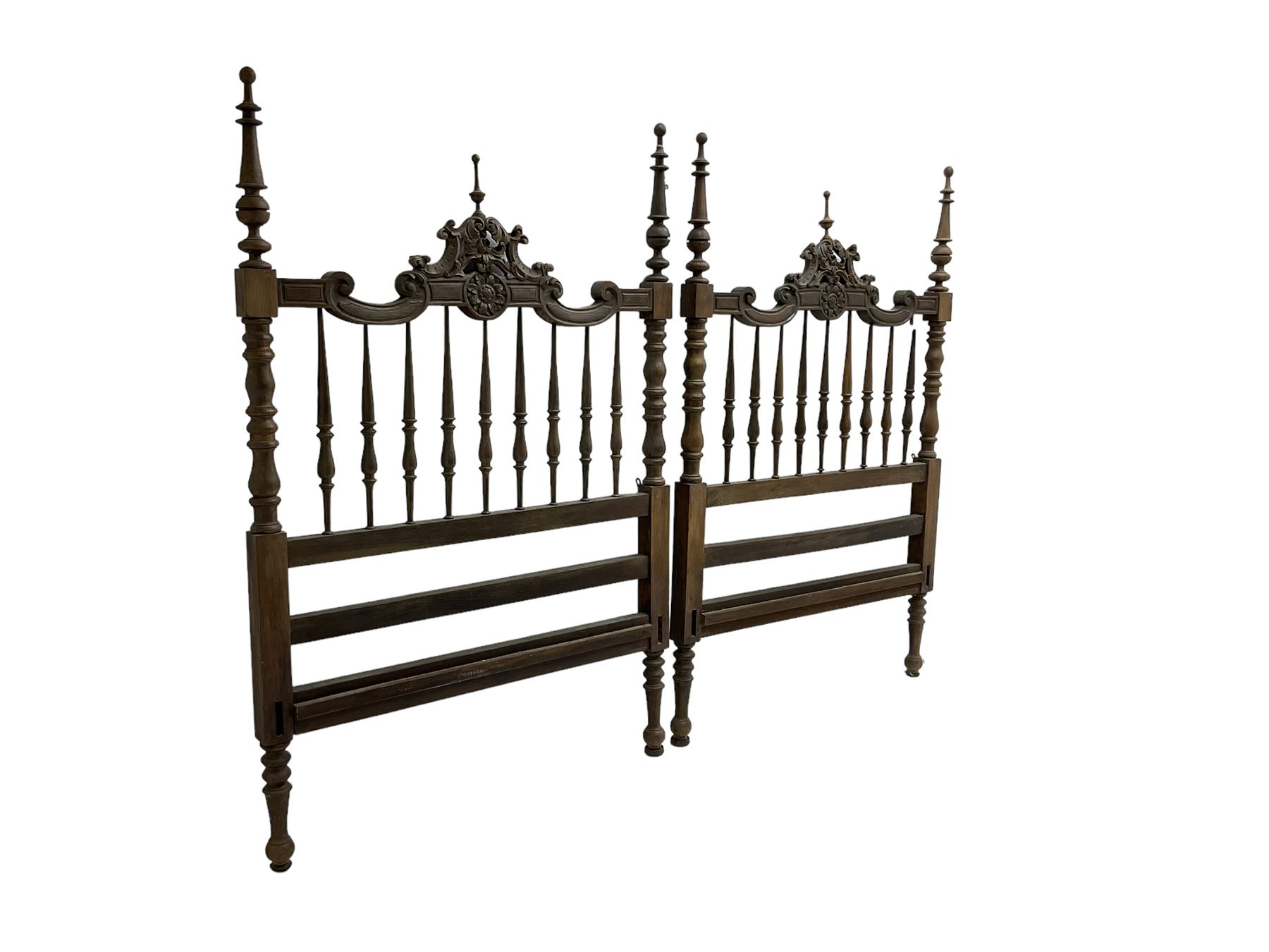 Pair Spanish stained beech single 3' bedsteads, spindle turned backs and carved with scrolling floral decoration 