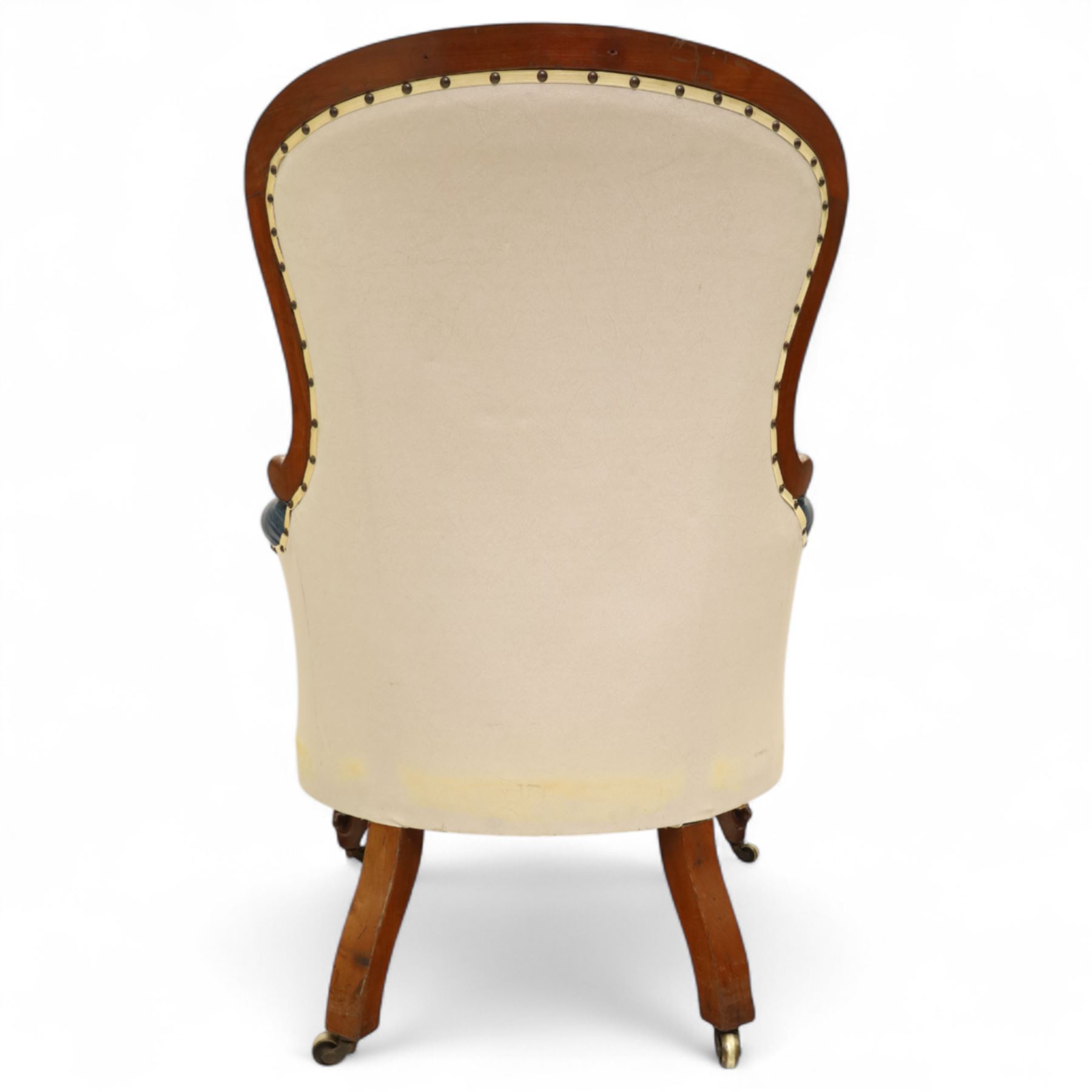 Fine pair of mid-19th-century mahogany library armchairs, carved frame with balloon-shaped back with scrolled ends, rolled wide arms, ending in a scrolled volute above a serpentine seat rail, upholstered in mottled turquoise faux leather, button upholstered back, arms, and cushion seat, studded sides and apron, raised on scroll carved front feet and splayed rear legs on castors 