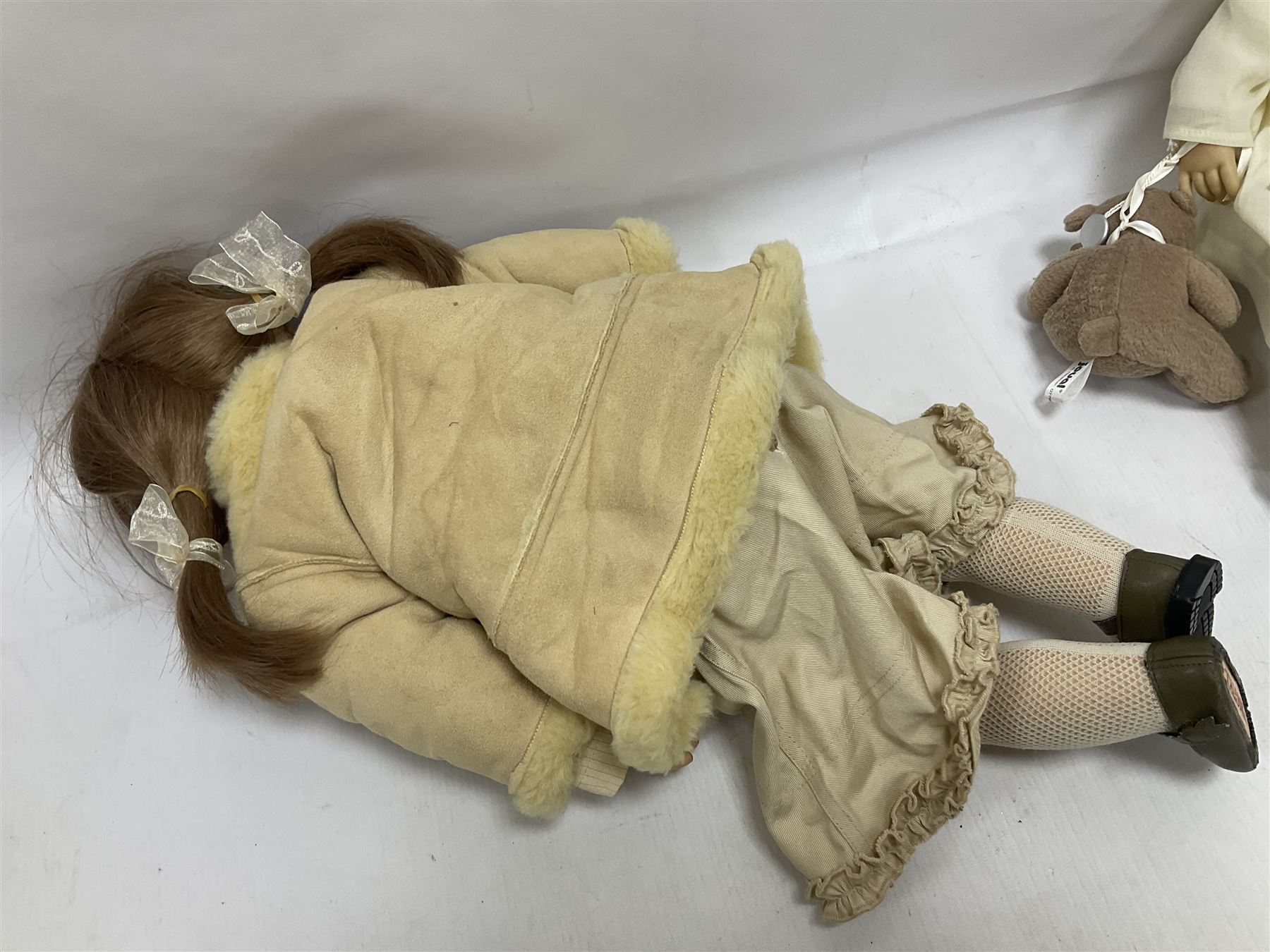 Two Zapf Creation limited edition designer collection dolls, by Brigette Paetsch, the first example with faux suede jacket, red jumper and denim skirt, no. 460, the second example 'Linda' in white dress with teddy bear accessory, no. 785, each signed B Paetsch, tallest L60cm