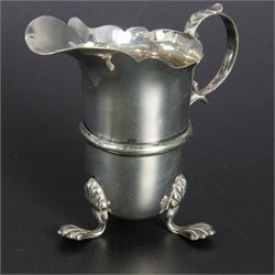 Group of early 20th century silver, comprising sauce boat, with flying scroll handle and upon three pad feet, two small cream jugs and a christening mug, all hallmarked, tallest H10cm