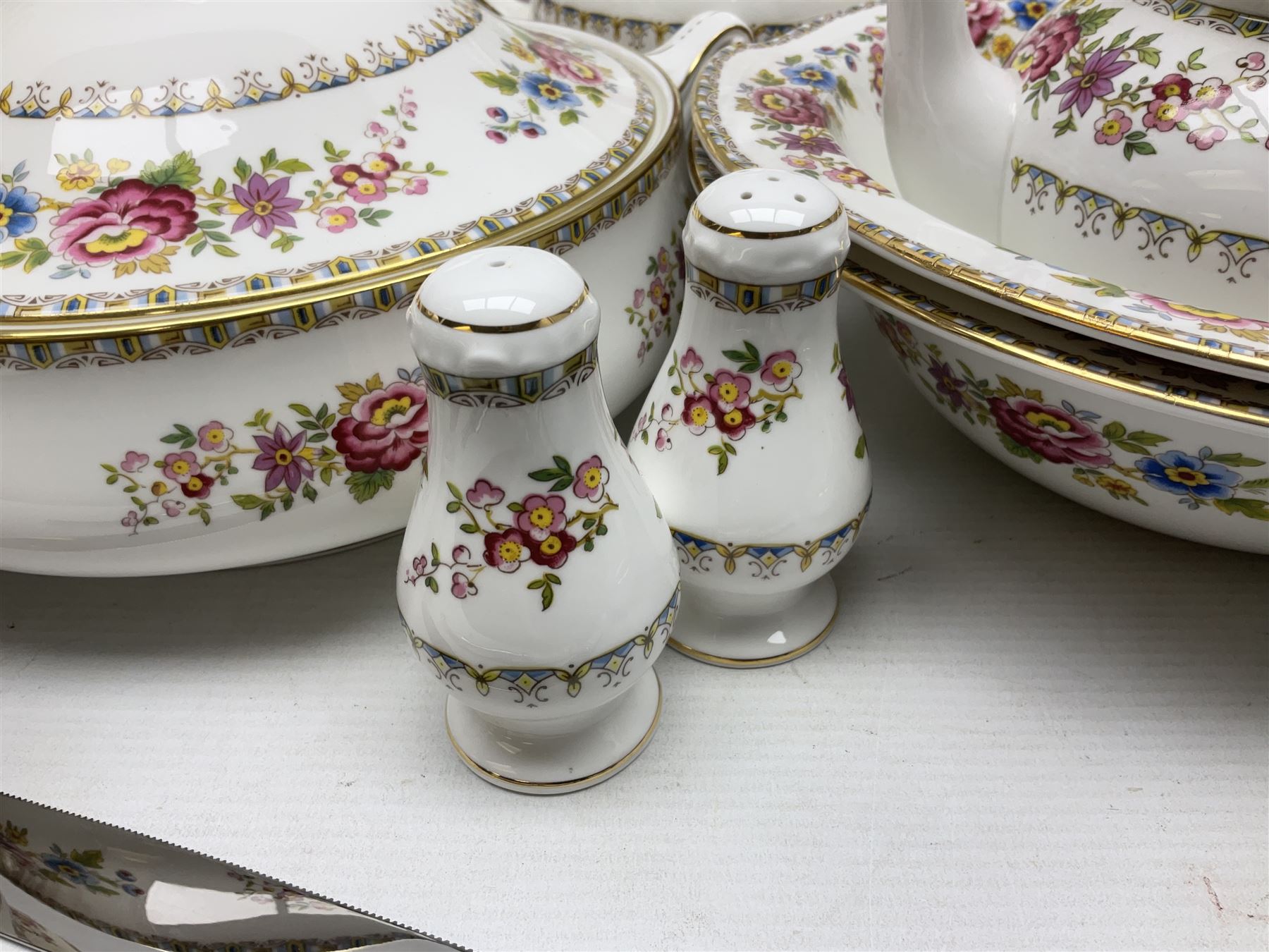 Extensive Royal Grafton Malvern pattern tea and dinner wares, comprising twelve dinner plates, six smaller plates, coffee pot, two teapots, two cake plates, eight teacups and ten saucers, six coffee cups and six saucers, two open sucriers, twin handled lidded sucrier, jug, lidded mustard pot and condiment jar, lidded tureen, two circular twin handled vegetable tureens, sauce boat and stand, oval and circular serving plates, salt and pepper shakers, breakfast cup and two saucers, further large cup and saucer, eighteen tea plates of various shapes, six side plates, six cereal bowls and six further bowls, shell dish and dish of square form, fork and knife, together with a hallmarked silver condiment spoon