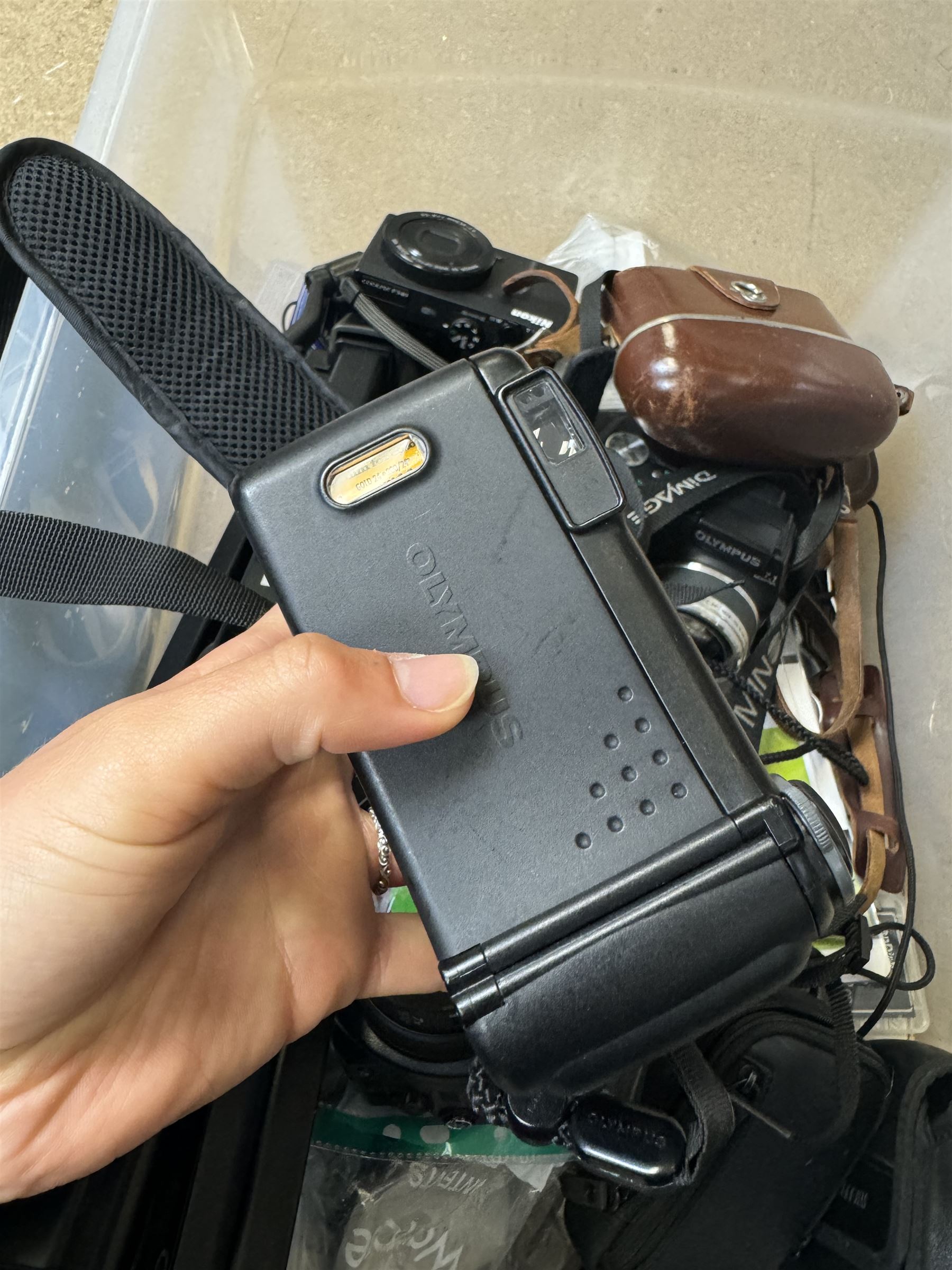 Collection of cameras and camera equipment, including Voigtlander Vitomatic I, Nikon Coolpix P340, Nikon Coolpix S9100, Olympus SP-510UZ, tripod, cases, etc