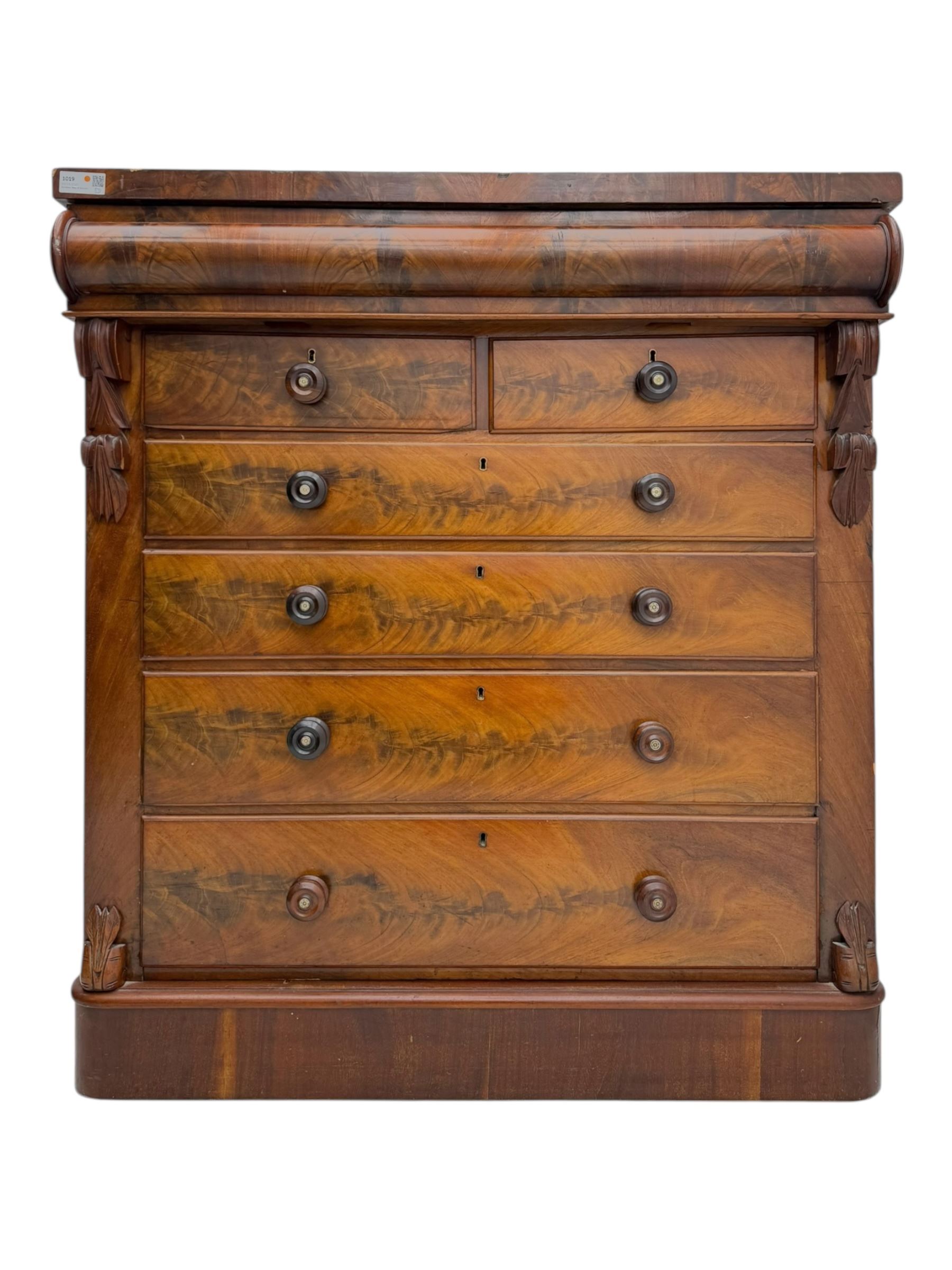 19th century flame mahogany Scotch chest, frieze long drawer above two short and four long graduating drawers, with turned knobs scrolled carved side bracket 