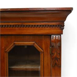 Victorian mahogany bookcase on cupboard of slender proportions, projecting cornice over dentil-frieze, fitted with twin-glazed doors enclosing three shelves, flanked by acanthus corbels, the base fitted with single frieze drawer over panelled cupboard, on skirted base