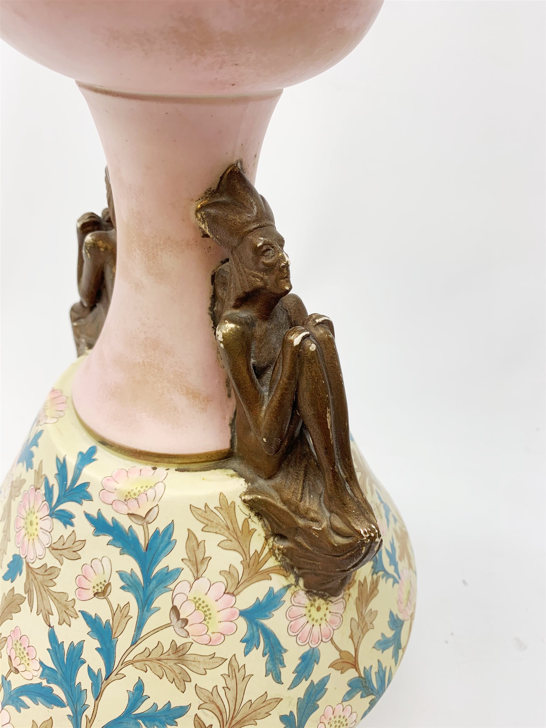 A late 19th century Aesthetic Movement Old Hall vase designed by Christopher Dresser, the flared body decorated with stylised flowering vines, leading to a tapering neck and flared rim with twin figural handles (one s/d), and raised upon a circular footed base, with printed mark beneath, H35cm. 