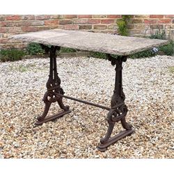 Cast iron garden table, 19th century, the stone flag top raised on end supports with kite ...