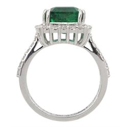 18ct white gold emerald and round brilliant cut diamond cluster ring, with diamond set shoulders, stamped 18K, emerald approx 4.85 carat, total diamond weight approx 0.70 carat