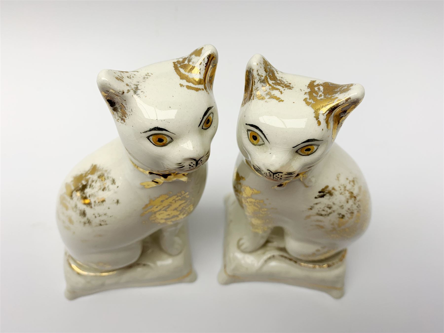 Pair of Victorian Staffordshire cats, modelled seated upon cushions, with gilt detail throughout, H18cm