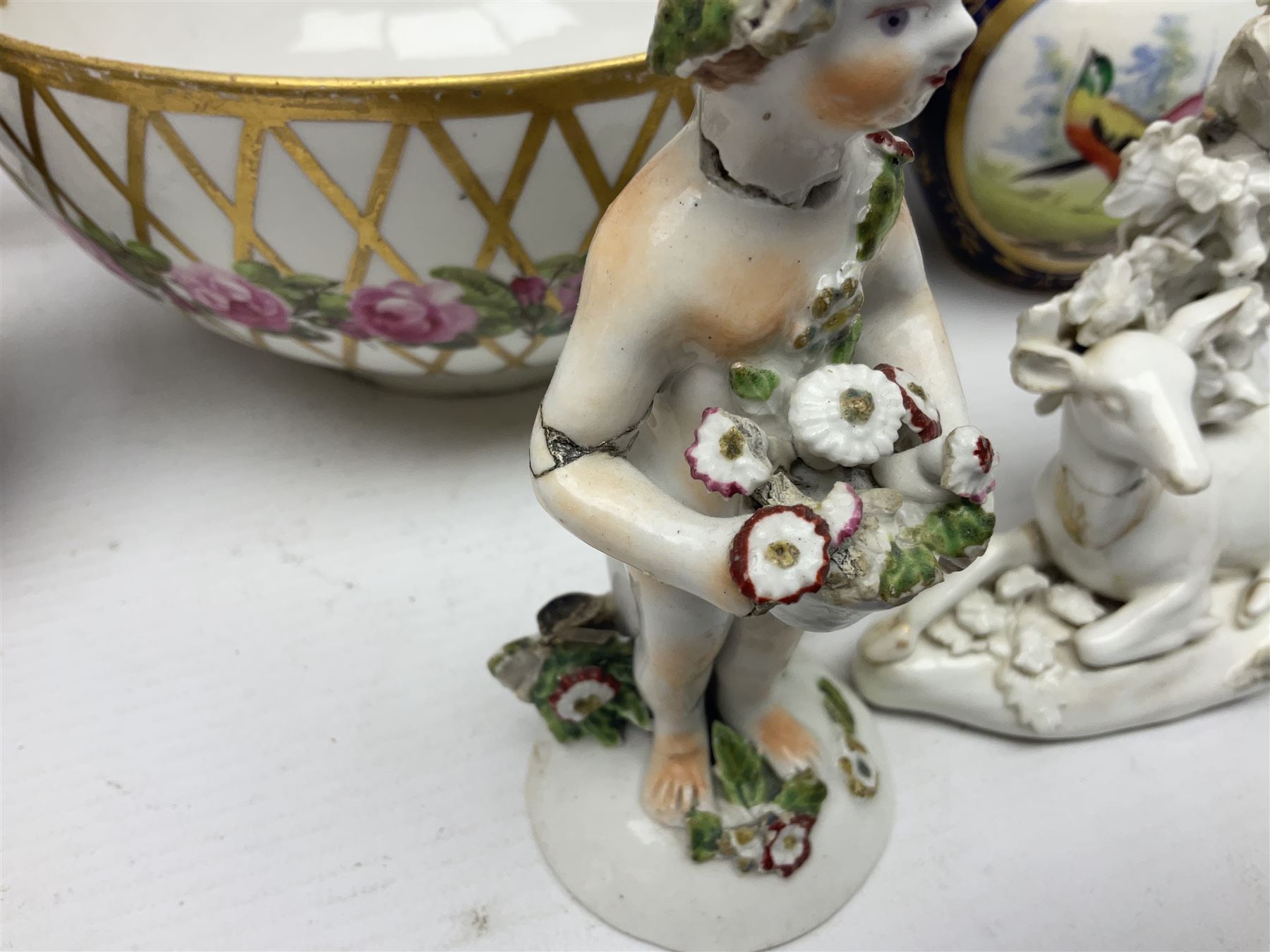 Group of 18th and 19th century ceramics for repair and restoration, to include an 18th century Derby figure emblematic of the Continent of Africa, pair of small 19th century Derby vases, painted with birds and floral spray, 19th century Derby slop bowl decorated in the 594 pattern with pink roses against gilt trellis, 19th century Derby figure of a recumbent deer, Serves style box, and two further figures