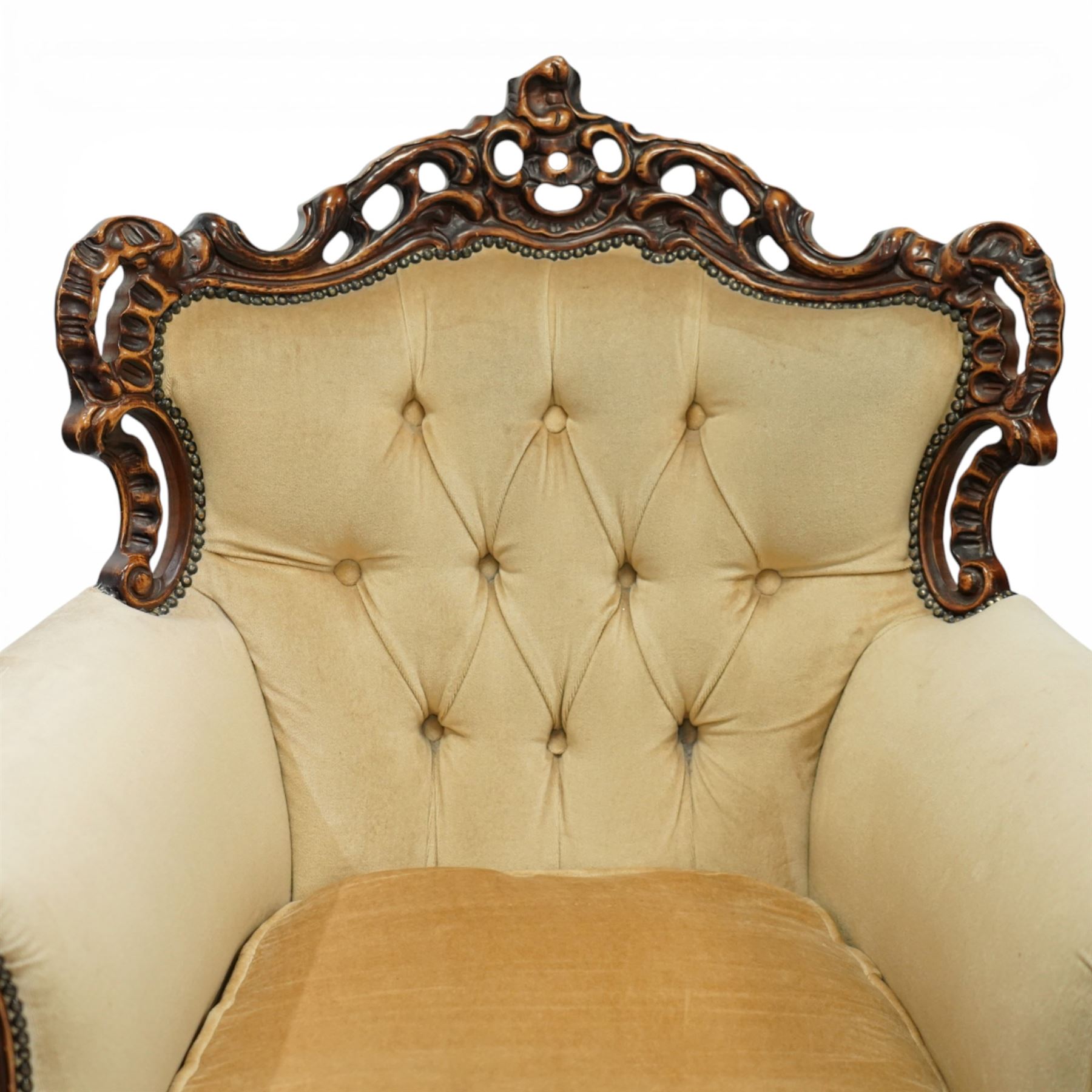 Late 19th century style carved hardwood armchair, the openwork crest rail with scrolling and foliate ornament, upholstered back and outscrolled arms with buttoning, loose seat cushion, nailhead trim, on carved cabriole legs