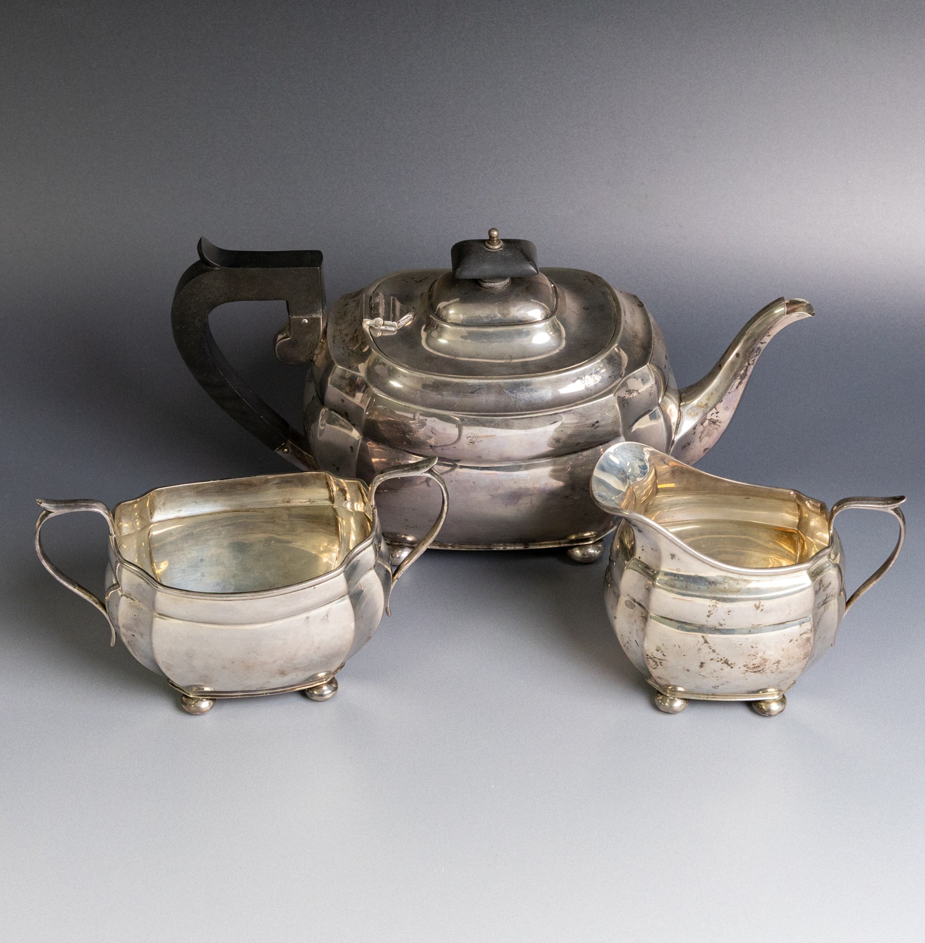 1930s silver three piece tea service, comprising teapot, milk jug and open sucrier, of oval form, the teapot with ebonised handle and finial, hallmarked S Blanckensee & Son Ltd, Chester 1931