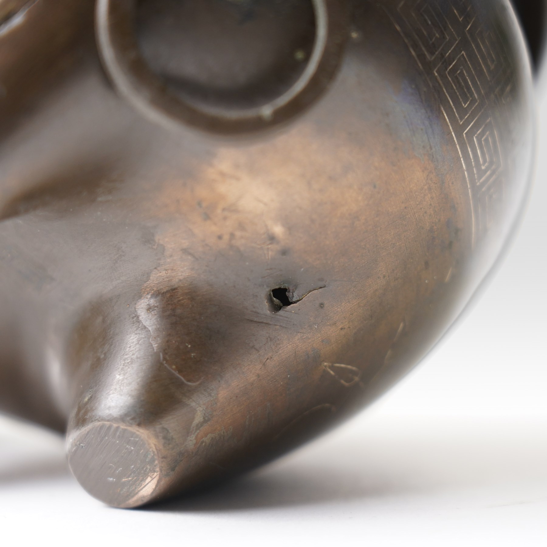 Chinese bronze tripod censer, of squat globular form, the body decorated with a band of Greek key motifs, the twin handles formed as two elephants heads, with incised shi shou two-character mark to base, H10cm