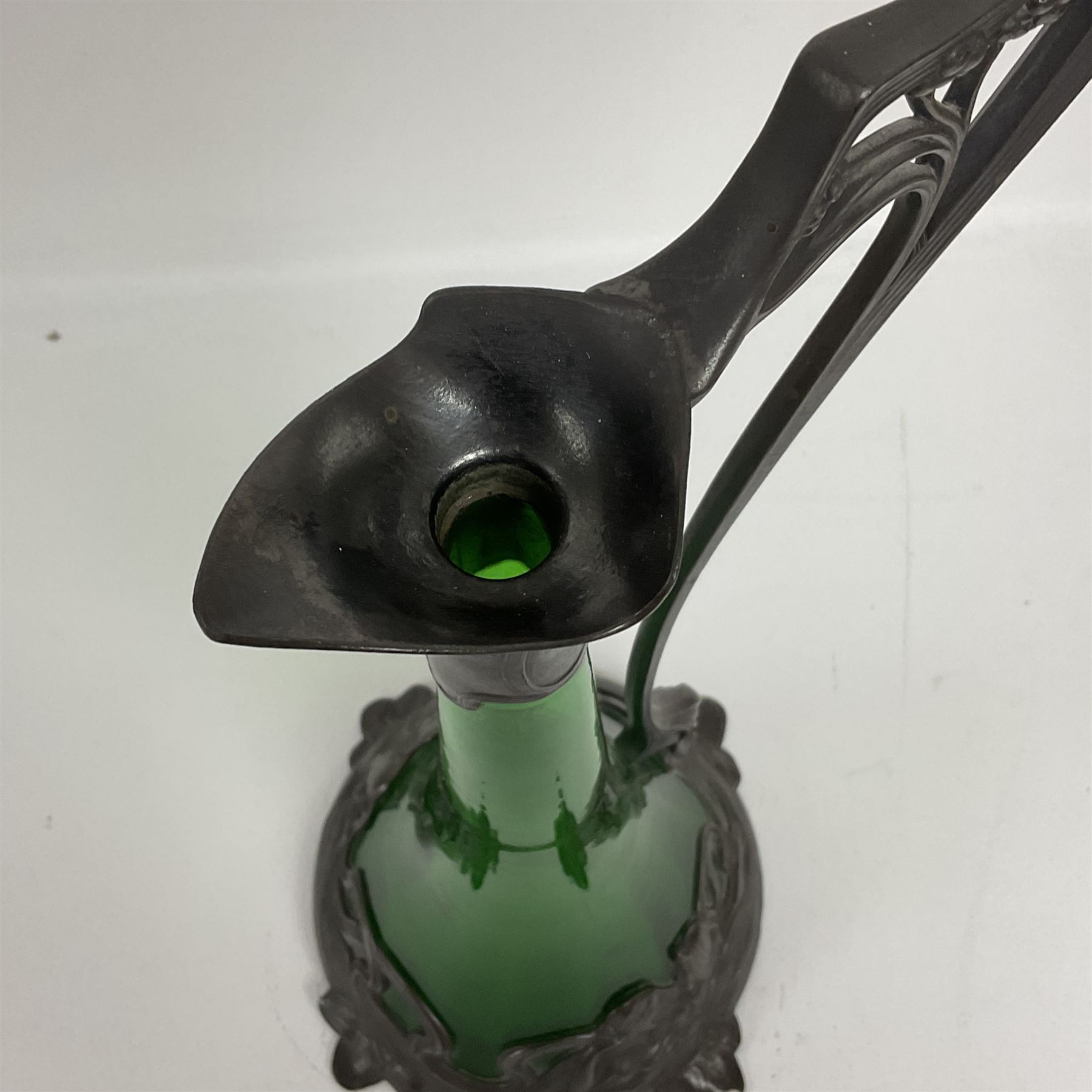 Early 20th century WMF Art Nouveau pewter and green glass ewer, of swept cylindrical form, having a pierced stopper and handle of entwined stems and berry design, the base cast as water nymphs with flowing hair and lily pads, H38cm