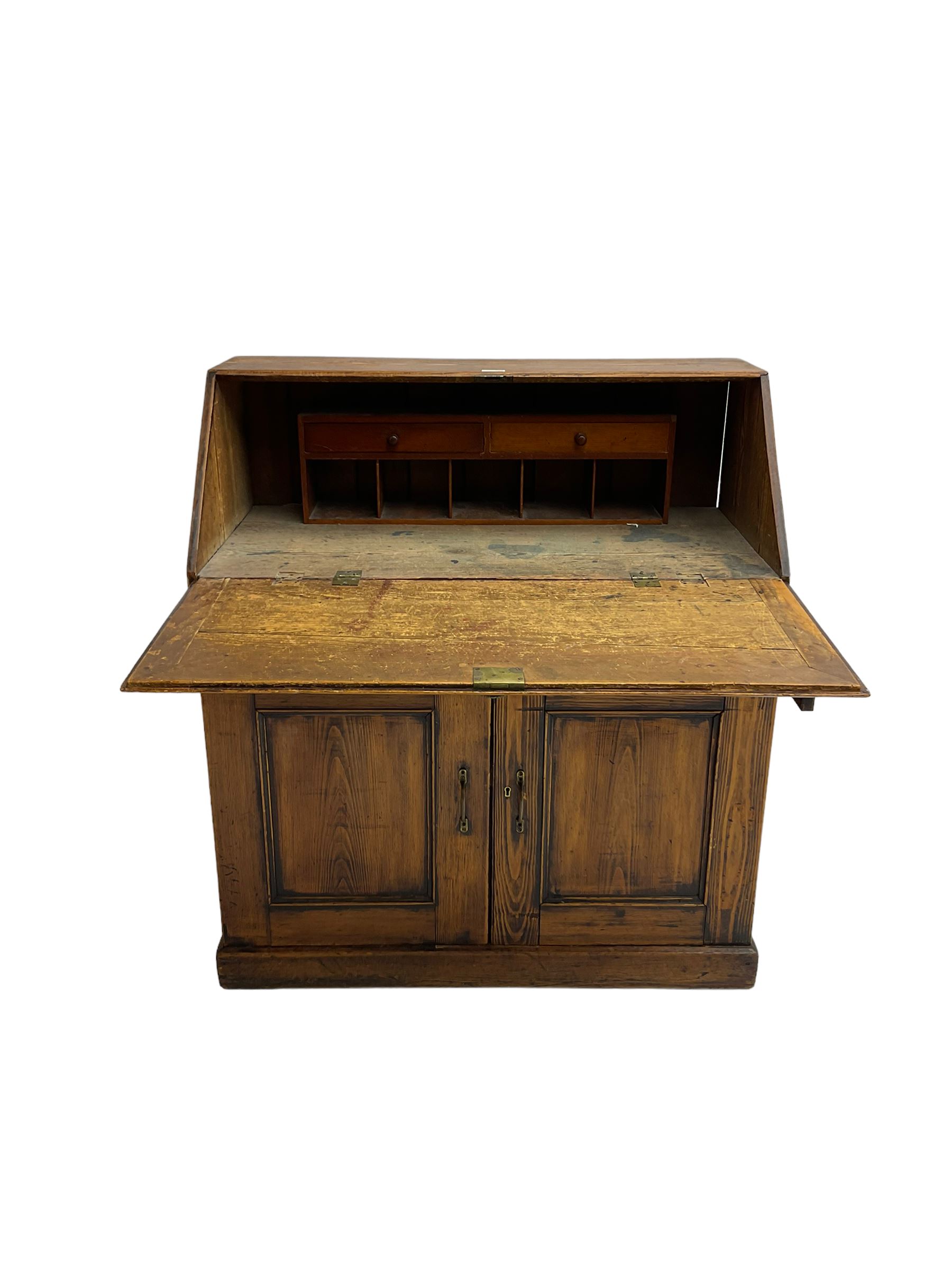 19th century waxed pine bureau, the fall front opening to reveal fitted interior with two drawers and five pigeonholes, base with single drawer over two panelled cupboard doors, on plinth base