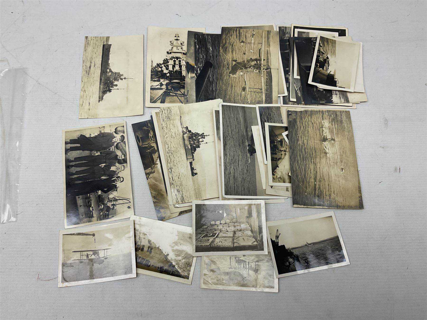 Disbound WW2 album relating to the battleship HMS King George VI containing over fifty various size loose photographs of the ship in action, guns firing, crew members, aircraft, two of George VI on board, three of Winston Churchill on board, official 1942 Christmas messages including Franklin Roosevelt etc; together with unrelated printed letter on 10 Downing Street notepaper from Winston Churchill; and Order of Service for Churchill's funeral at St. Paul's Cathedral 30th January 1965