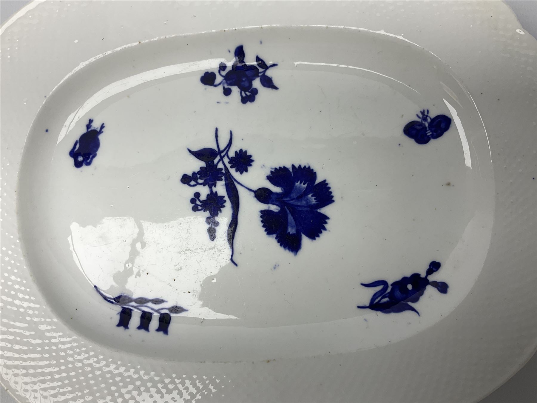 Three 19th century plates, comprising two circular examples and one oblong, each with osier moulded sides, the centres decorated in underglaze blue with Gillyflower type pattern, circular examples D25cm oblong example W27cm