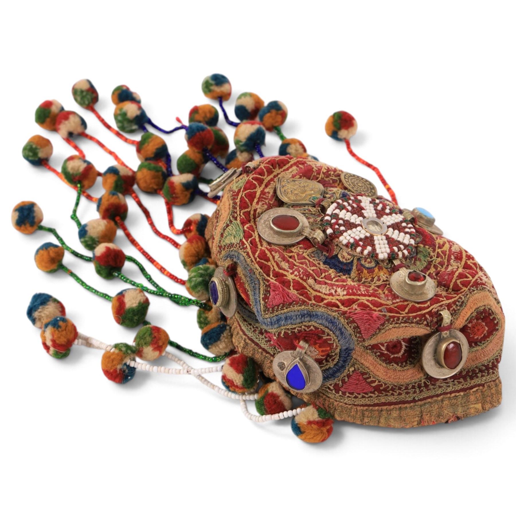 Collection of Middle Eastern jewellery, including silver necklace with a crescent  shaped pendent with beadwork and barrel tasselled ends, nickel silver wedding necklace with filigree decoration, coin bracelet, two bridal wedding caps and two others 