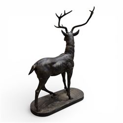 Pair of life-size cast iron garden or home stags, modelled standing upon oval plinths