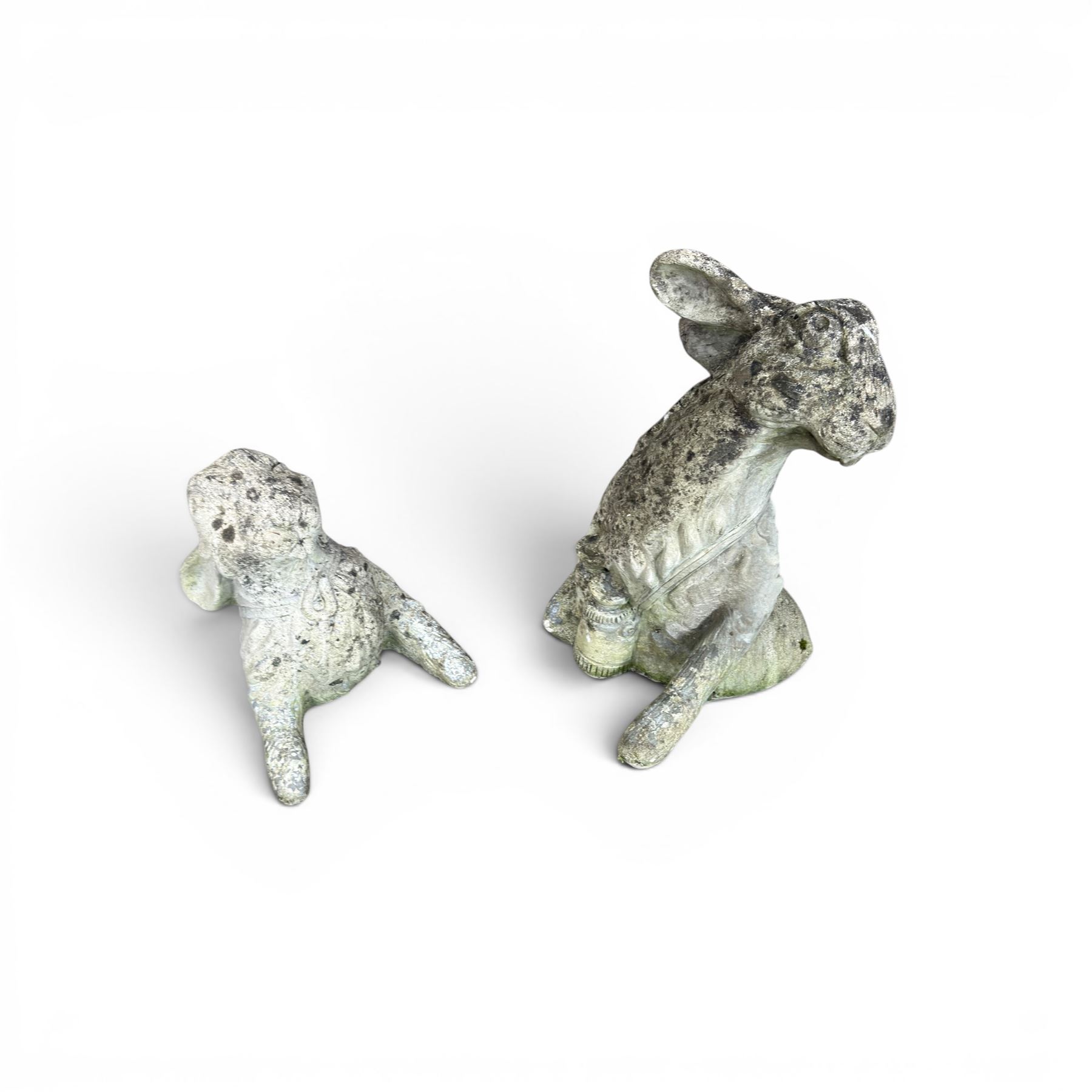 Two weathered cast stone garden hares