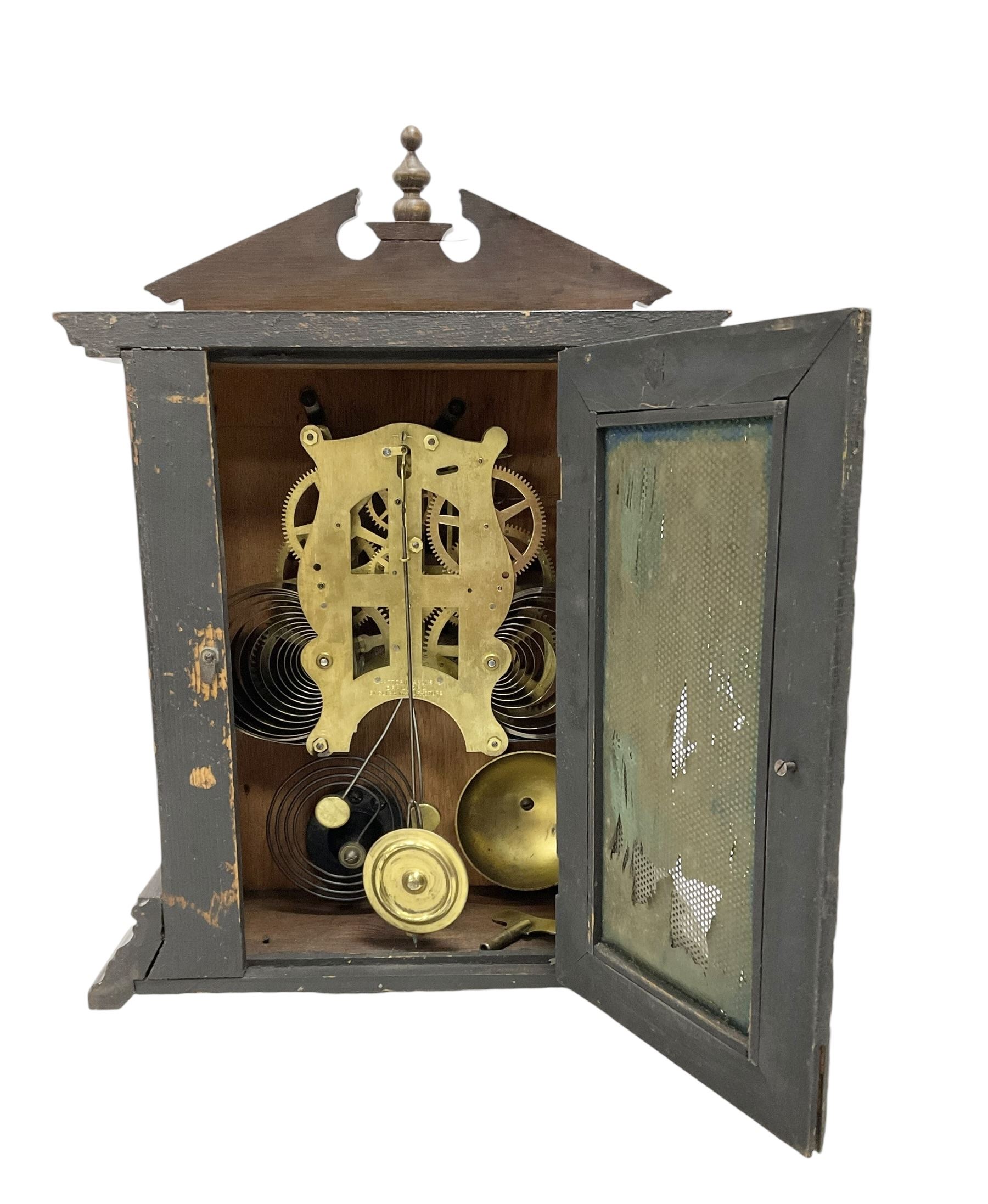 Fattorini of Bradford - oak cased early 20th century mantle clock with alarm, rectangular case with a broken pediment, turned finial and matching carved pilasters to the front, on a broad stepped plinth with a flat base, circular dial with an ivorine chapter within a decorative gilt bezel, Arabic numerals , spade hands and alarm setting disc to the centre, two train spring driven movement striking a coiled gong and bell. With key and pendulum. 