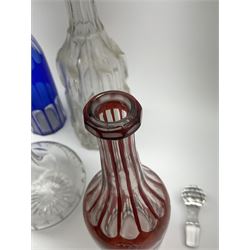Group of glass decanters, to include blue overlaid example with slice cut decoration, and a ruby flashed example with fruiting vine and slice decoration, plus Victorian and later examples, (not all stoppers original).