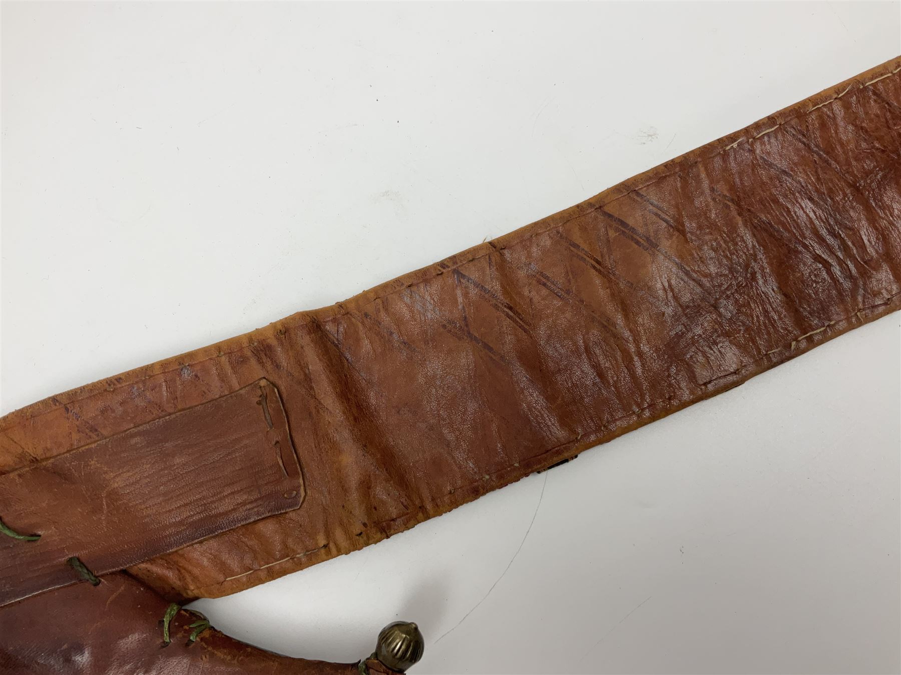 Late 19th century Yemeni Tuza jambiya as worn by religious elite, the 20.5cm curving blade with raised medial ridge, the horn hilt with pique style studwork, in a leather wrapped wooden scabbard with pierced metal mount and leather belt applied with embroidered 'gold' and 'silver' thread work panel; dagger L36cm overall, belt L84cm