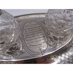 Victorian silver desk stand, of oval form, with beaded rim and twin handles, engraved with lattice and floral decoration and with personal engraving to centre 'Presented to the Revd James Connor by members of his congregation and other friends in remembrance of his faithful ministerial services amongst them, Thytherton Sept 1868' with two recesses, each containing a faceted glass inkwell with star cut base and silver covers, hallmarked H J Lias & Son, London 1867, including inkwells H13cm