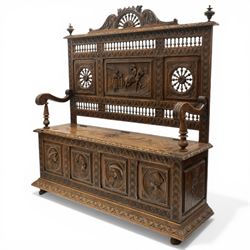 19th century European heavily carved oak hall settle, the impressive high-back with a pierced and carved acanthus pediment, over foliate and rosette carved back rails, flanking a central panel depicting a gentleman on horseback drinking, the hinged box seat over a quadruple panelled front with relief carved busts, lower moulded and carved edge on compressed bun feet
