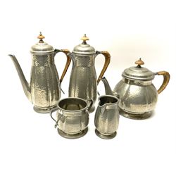 A Liberty & Co Tudric Petwer Arts and Crafts five piece tea and coffee set, comprising teapot, coffee pot, hot water pot, cream jug, and twin handled sucrier, with planished finish and woven handle to teapot, coffee pot, and hot water pot, with impressed marks beneath and numbered 01385