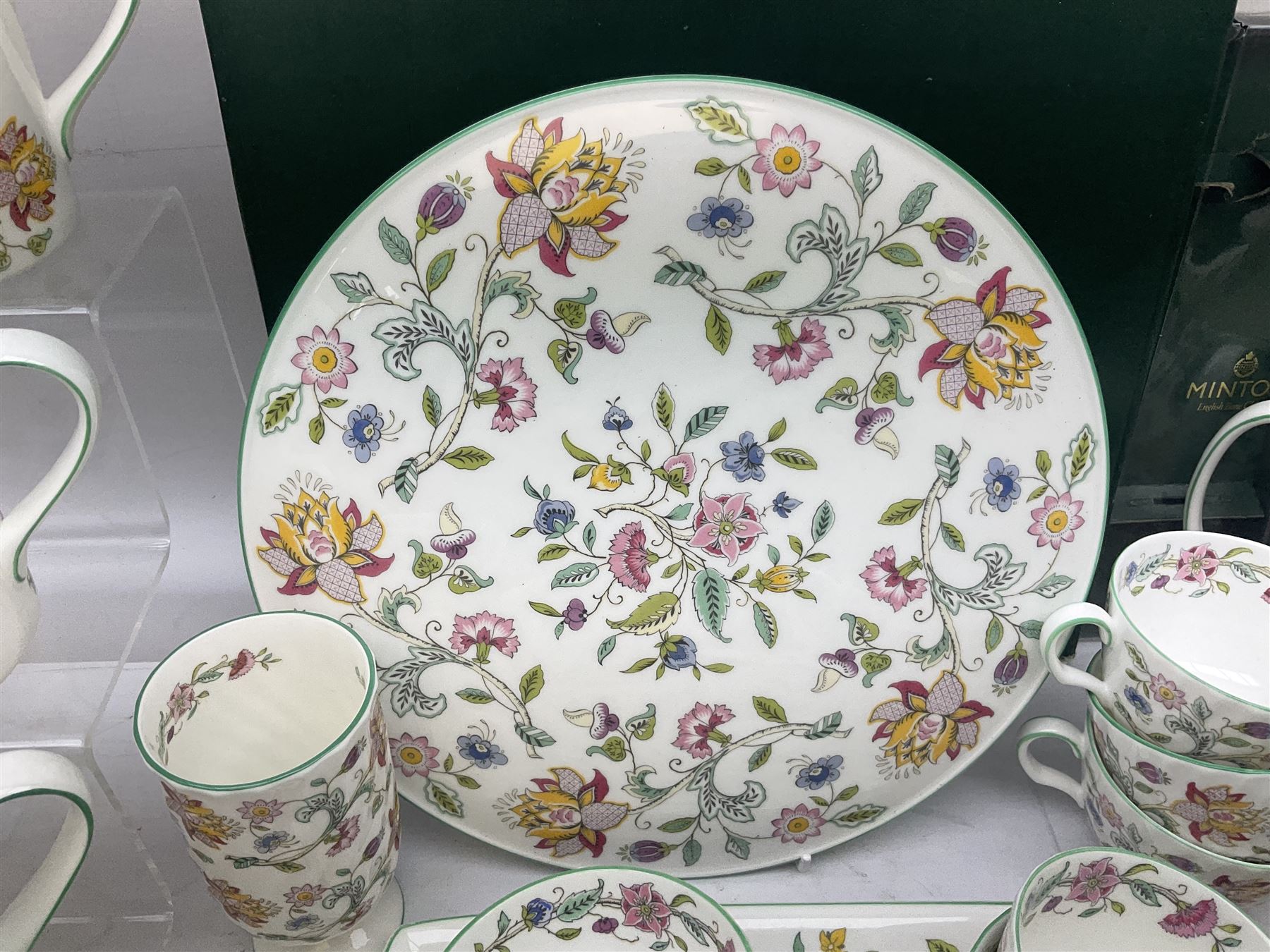 Minton Haddon Hall pattern tea and dinner wares, including basket dish, two covered tureens, six dinner plates, eight dessert plates, twelve tea plates, six soup bowls, six cereal bowls, teapot, coffee pot, milk jug, covered sucrier twelve tea cups and saucers, six mugs, footed bon bon dish, pair of candlestick holders, cake knife and slice etc (81)