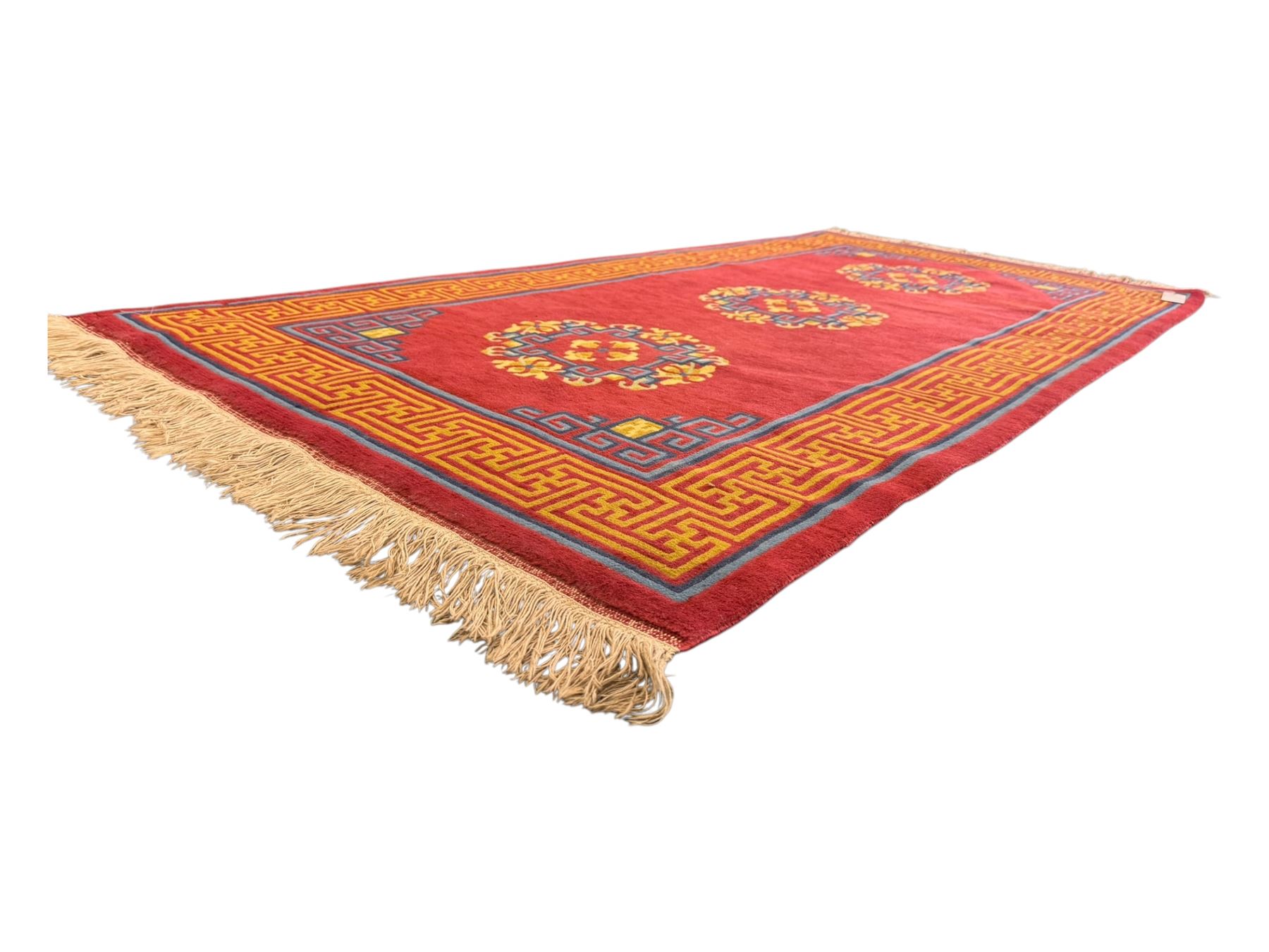 Tibetan-design handwoven rug, deep red field with three central medallions in yellow and blue, traditional yellow key border, white fringes on both ends