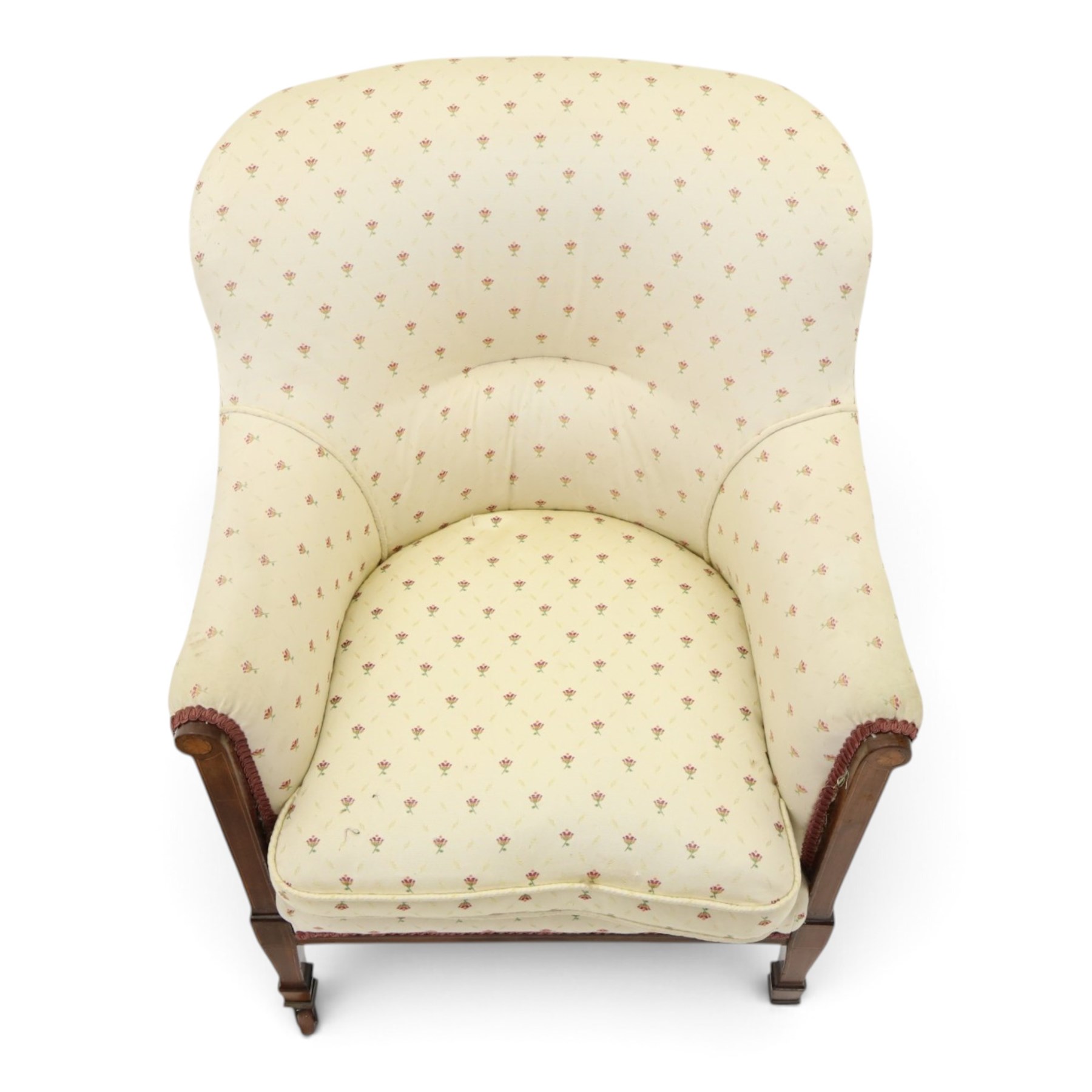 Edwardian inlaid mahogany armchair of modest proportions, spoonback and loose seat cushion on sprung seat upholstered in ivory ground floral fabric, on square tapering supports with ceramic castors
