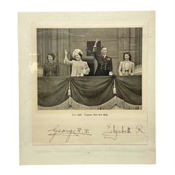 King George VI and Queen Elizabeth - the photograph and signatures only from a 1945 Christmas card depicting The Royal Family waving from the balcony of Buckingham Palace, on V-E Day Tuesday May 8th 1945, signed 'George R.I. Elizabeth R.'