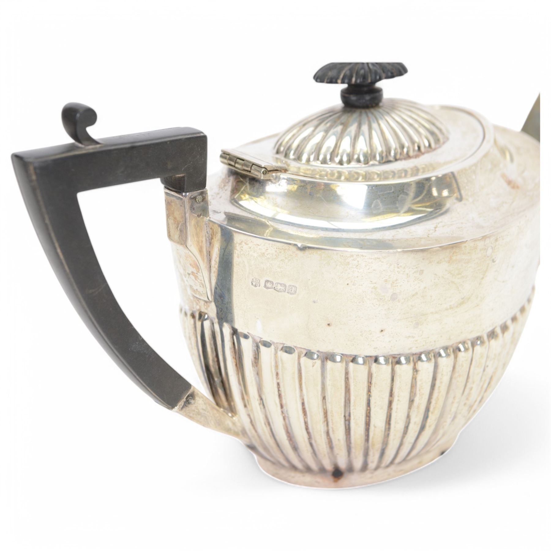 Early 20th century four piece silver tea service, comprising teapot, hot water pot, open sucrier and milk jug, all of oval part fluted form, the teapot and hot water pot with Bakelite type handles and finials, hallmarked James Deakin & Sons (John & William F Deakin), Sheffield 1918
