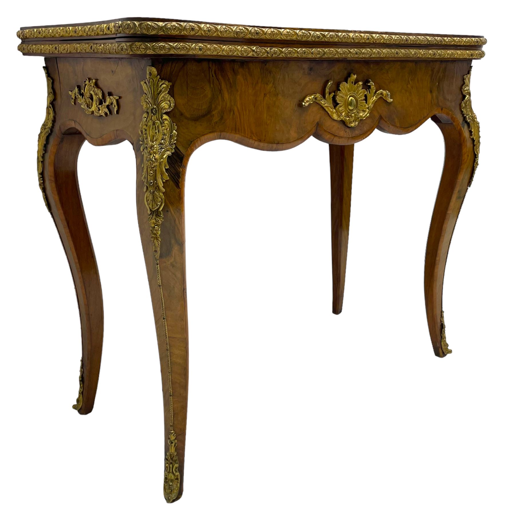 20th century French walnut and Kingwood card table, shaped fold-over top with figured quarter-matched veneers and floral egg and dart moulded edge in gilt metal, shaped aprons decorated with shell motifs with extending foliage, pull-out action base revealing storage well, on cabriole supports with ornate gilt metal mounts 