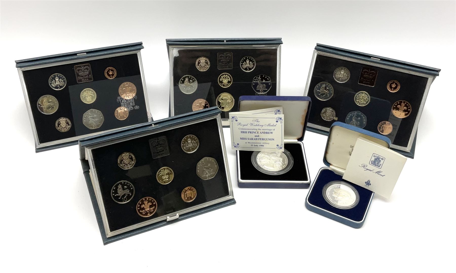 Five Royal Mint United Kingdom proof coin collections dated 1983, 1984, 1985 and 1986, all in blue folders with certificates, silver proof 1981 crown and a sterling silver medal 'Commemorating the marriage of HRH Prince Andrew and Miss Sarah Ferguson at Westminster Abbey 23 July 1986' weighing 37 grams, both cased with certificates (6)